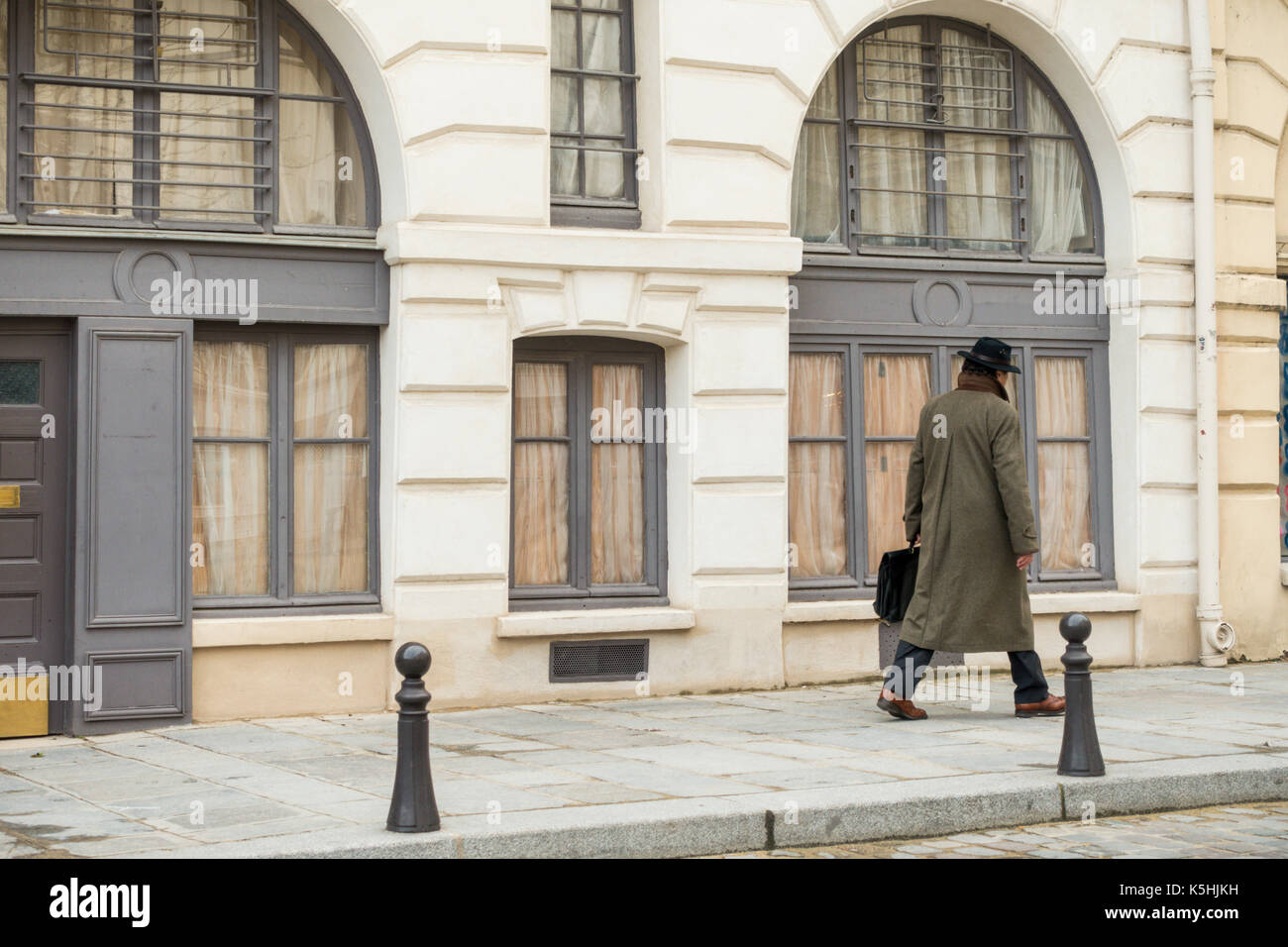 L'homme en manteau et hat carrying briefcase dans la place Dauphine dans l'île de la cité Banque D'Images