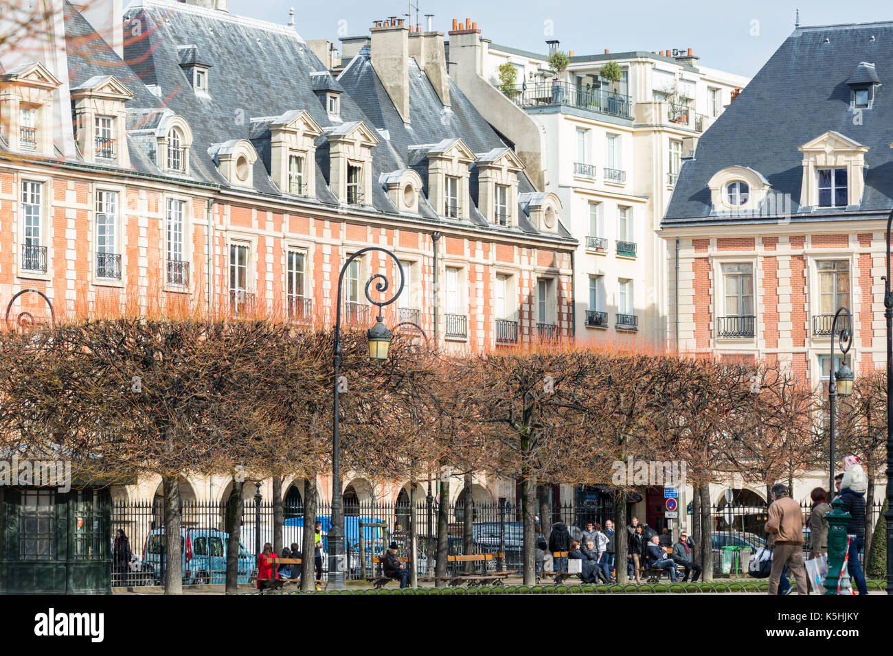 Le soleil brille, les gens à la place des Vosges dans le marais, Paris Banque D'Images