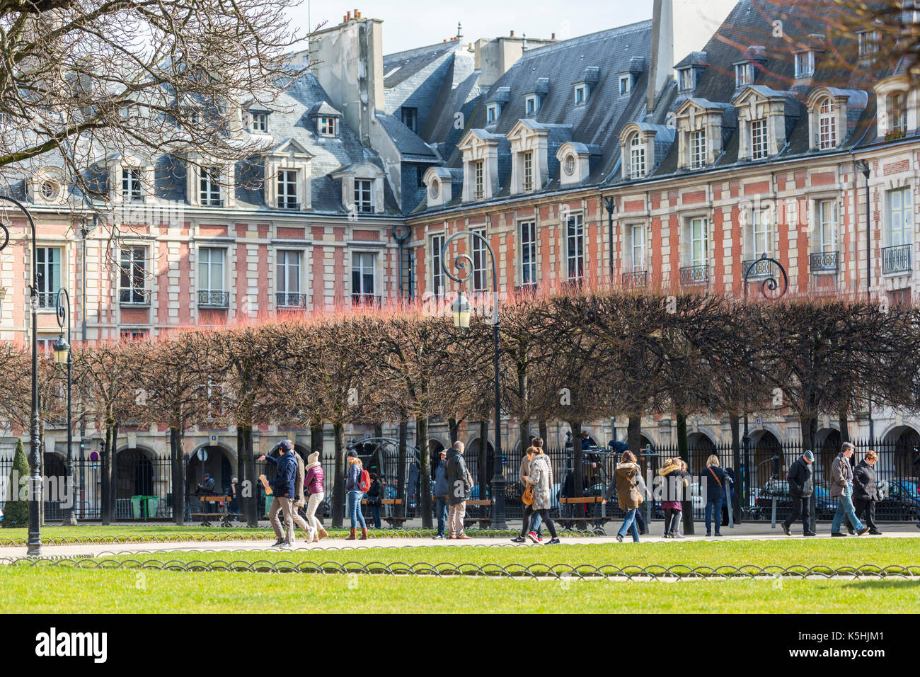 Le soleil brille, les gens à la place des Vosges dans le marais, Paris Banque D'Images