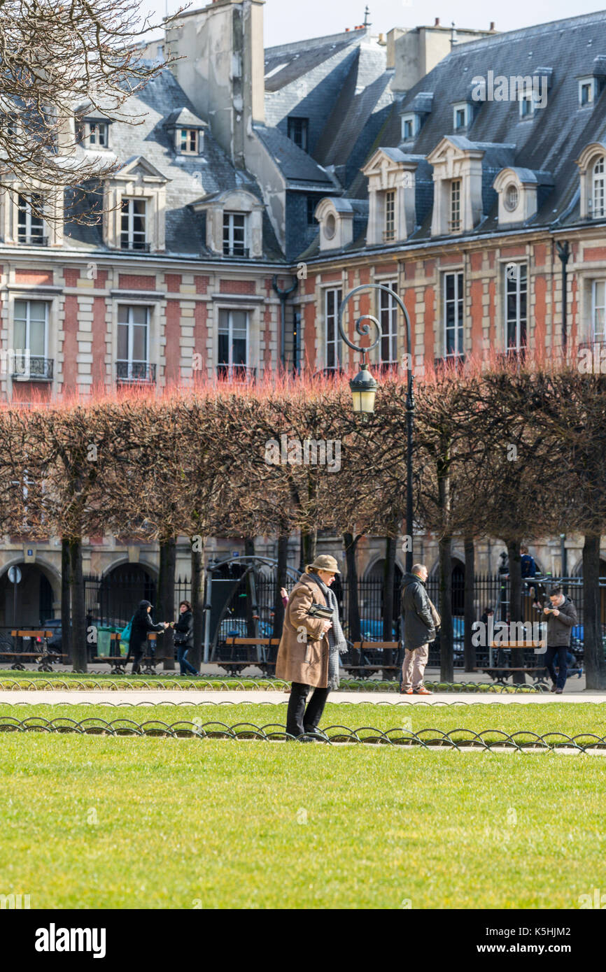 Le soleil brille, les gens à la place des Vosges dans le marais, Paris Banque D'Images