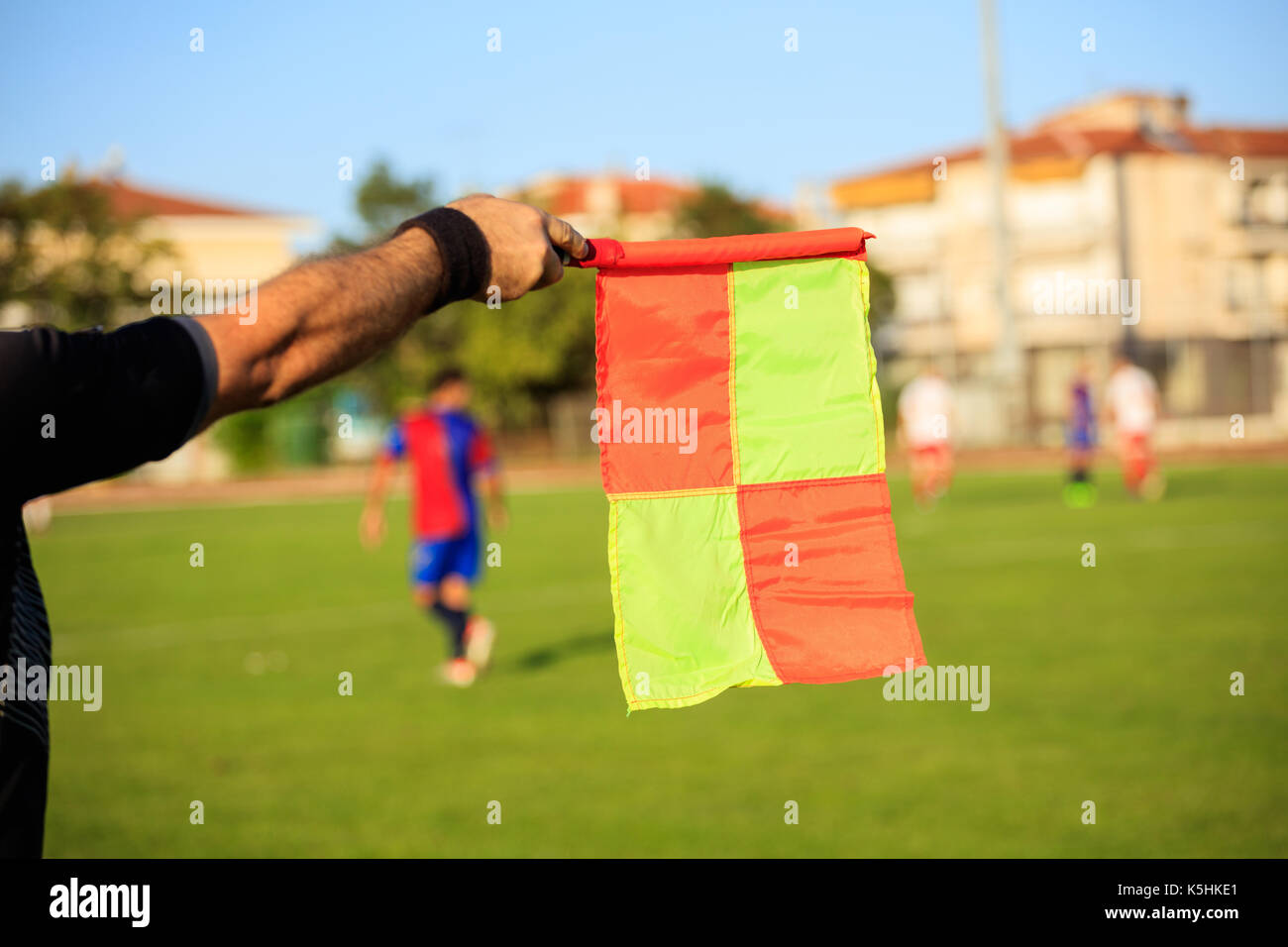 Le soccer (football) arbitre assistant avec drapeau sur le champ vert Banque D'Images