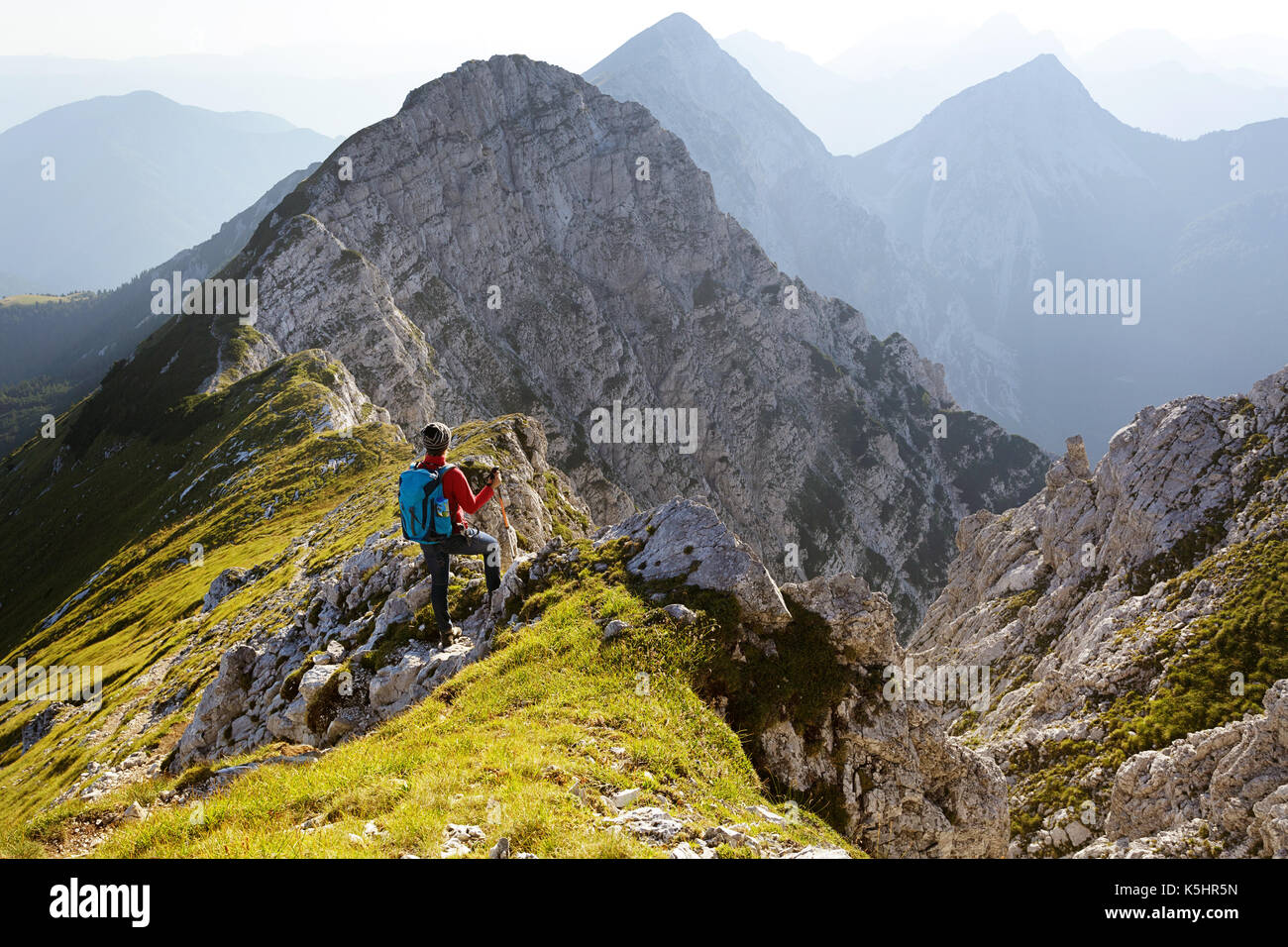 Veste femme en rouge, avec des bâtons de randonnée et randonnées sac à dos jusqu'à un point de vue sur le massif des Karavanke, Kladivo, la Slovénie. Banque D'Images