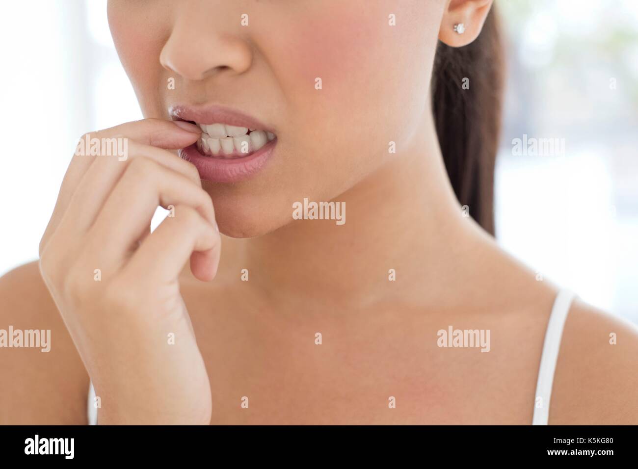 Young woman biting nails. Banque D'Images