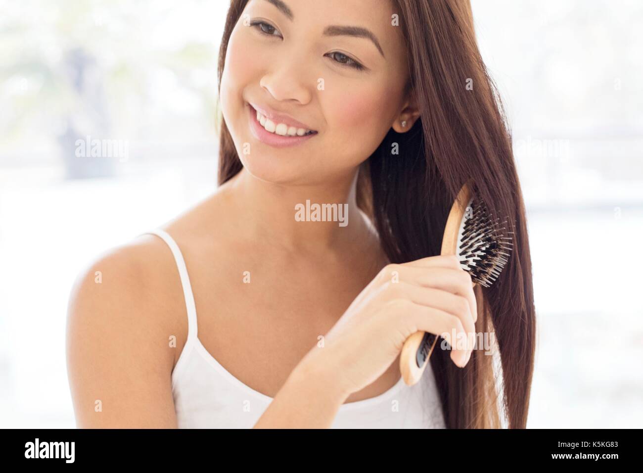 Jeune femme se brosser les cheveux. Banque D'Images