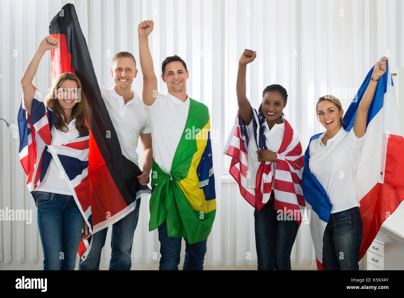 Groupe d'amis heureux avec des drapeaux de différentes nations Banque D'Images