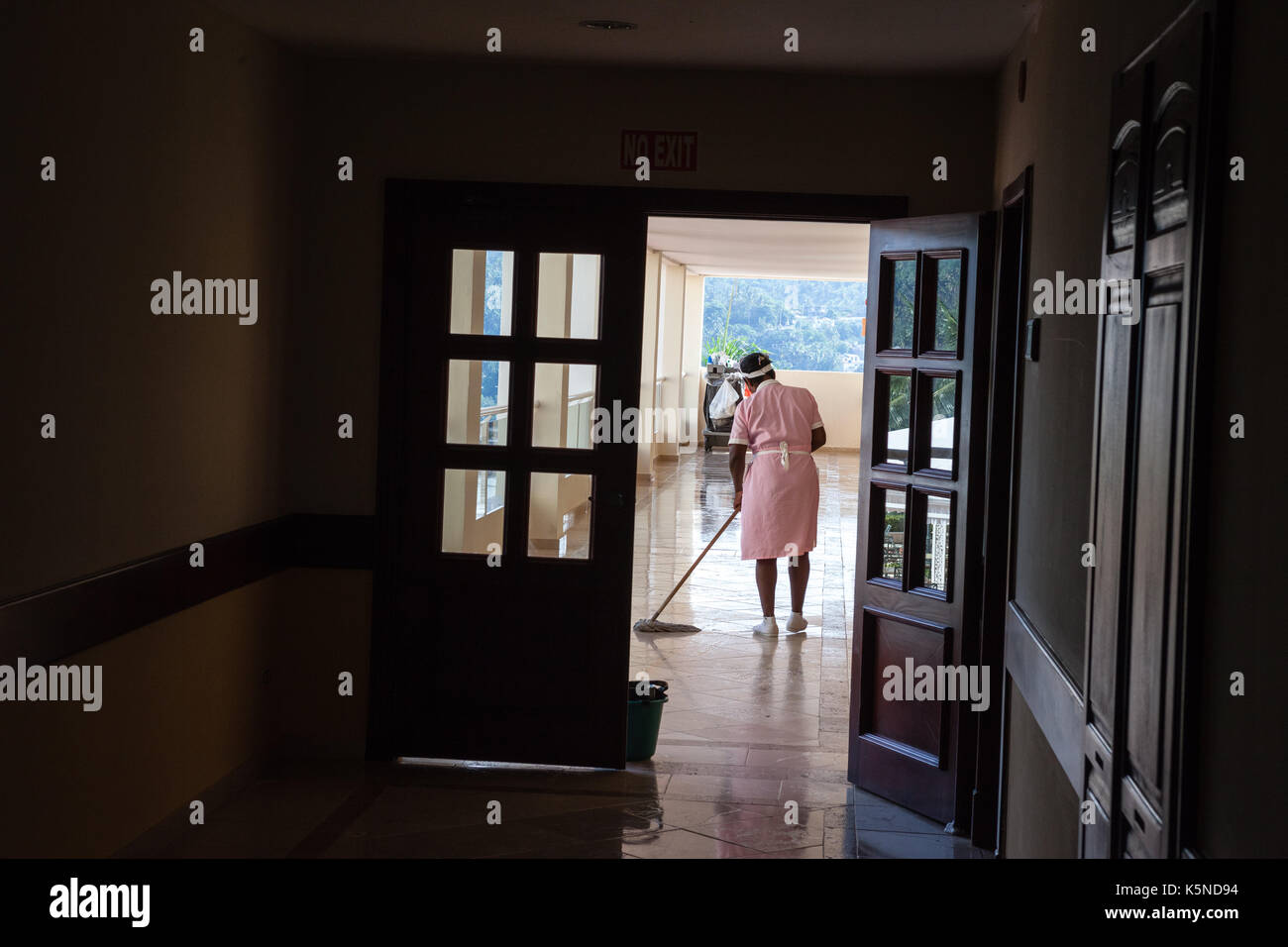 Femme nettoyant une allée d'hôtel Banque D'Images