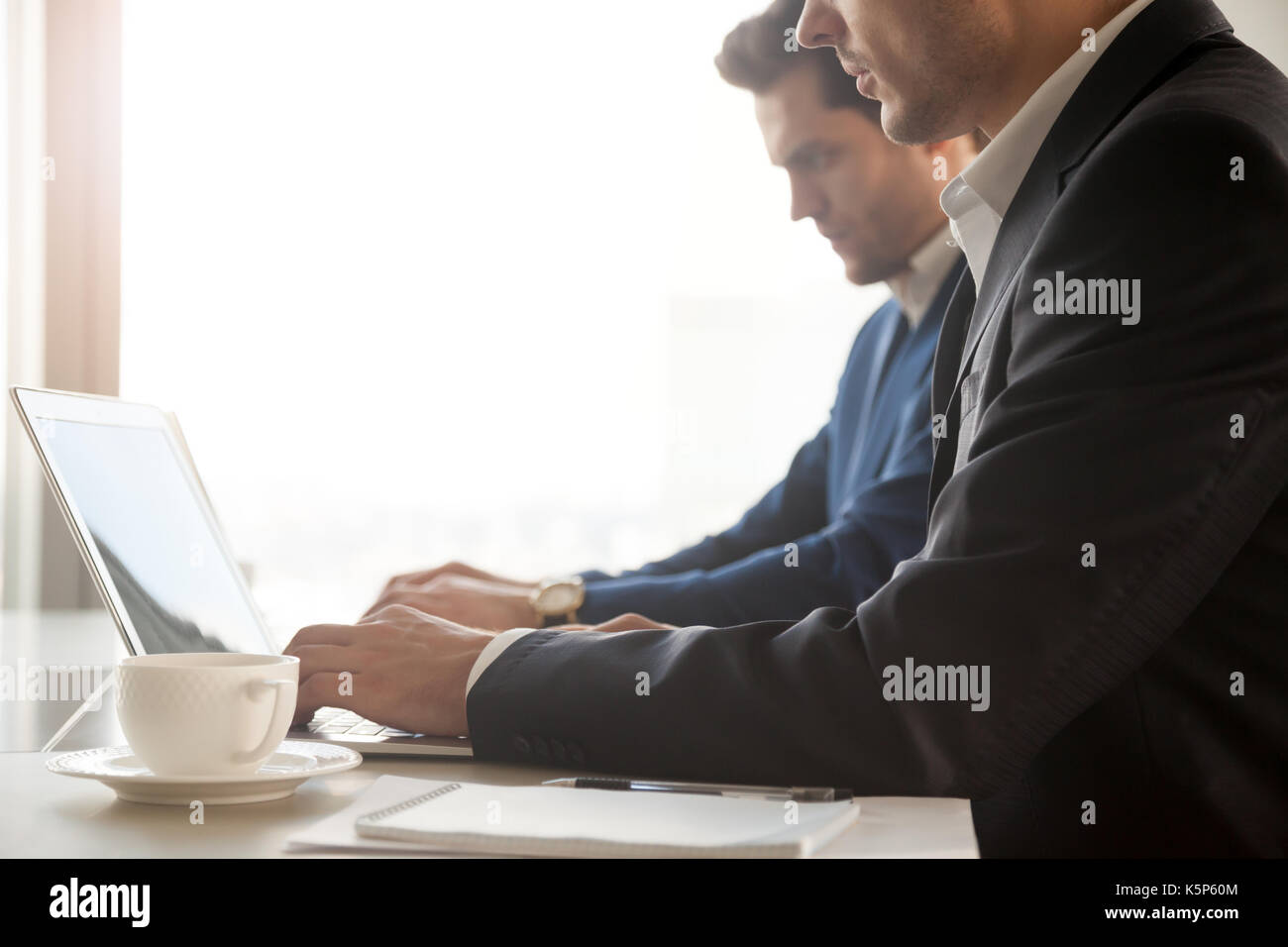 Les employés de l'entreprise travaillant sur des ordinateurs portables in office Banque D'Images