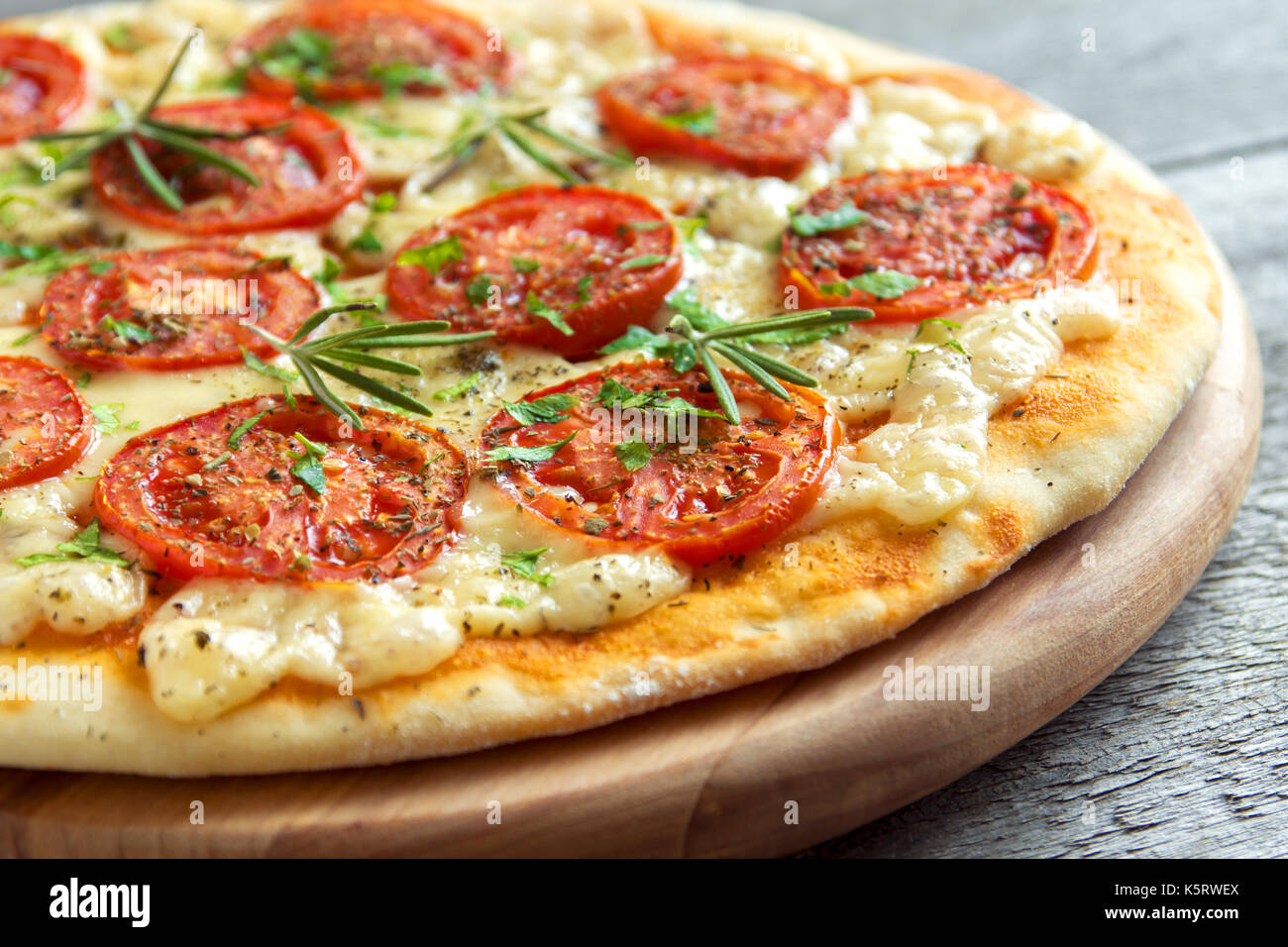 Pizza Margherita avec tomates, fromage, basilic et romarin. mince maison pizza végétarienne. Banque D'Images