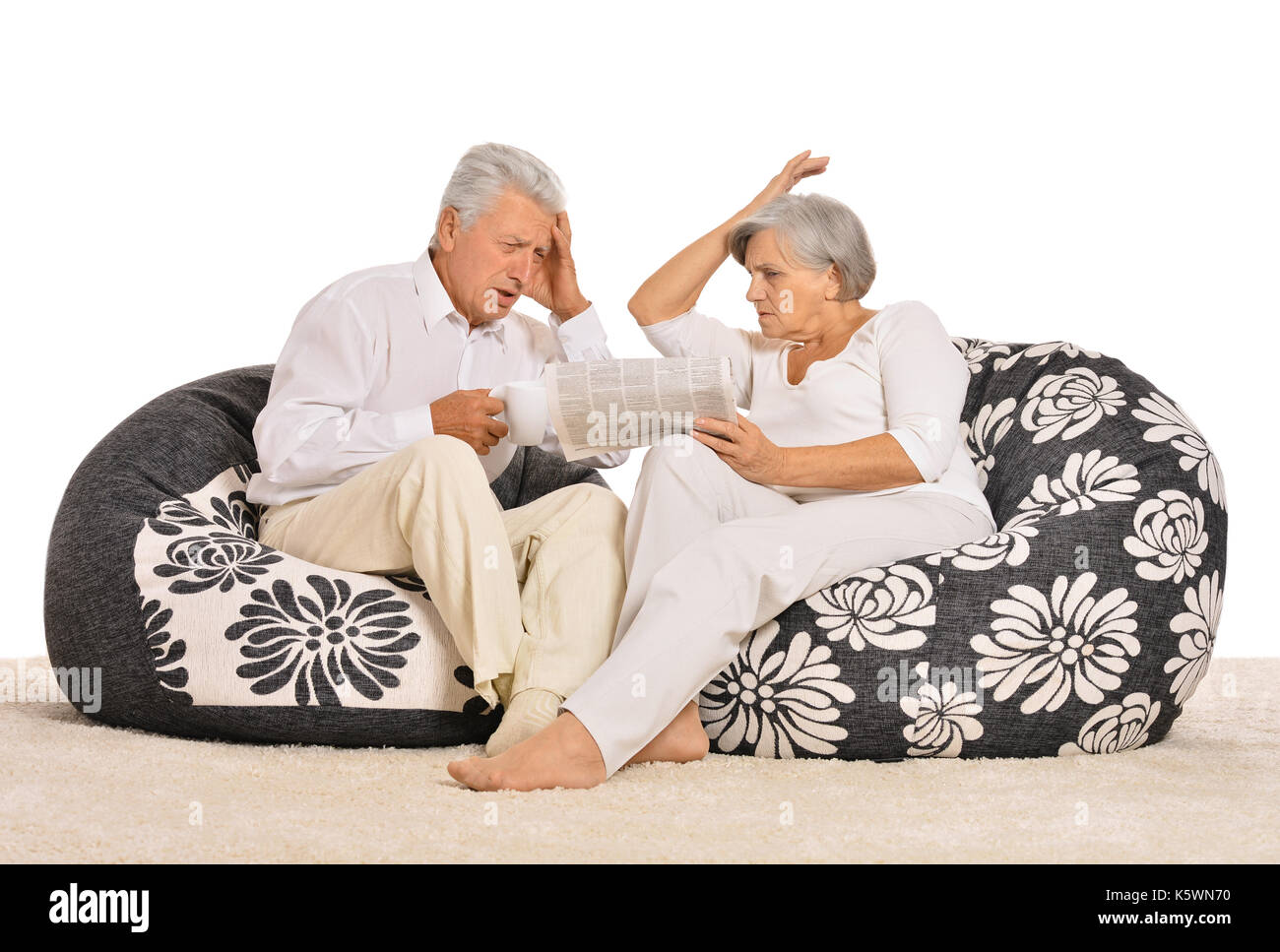 Couple assis dans un fauteuil avec journal Banque D'Images