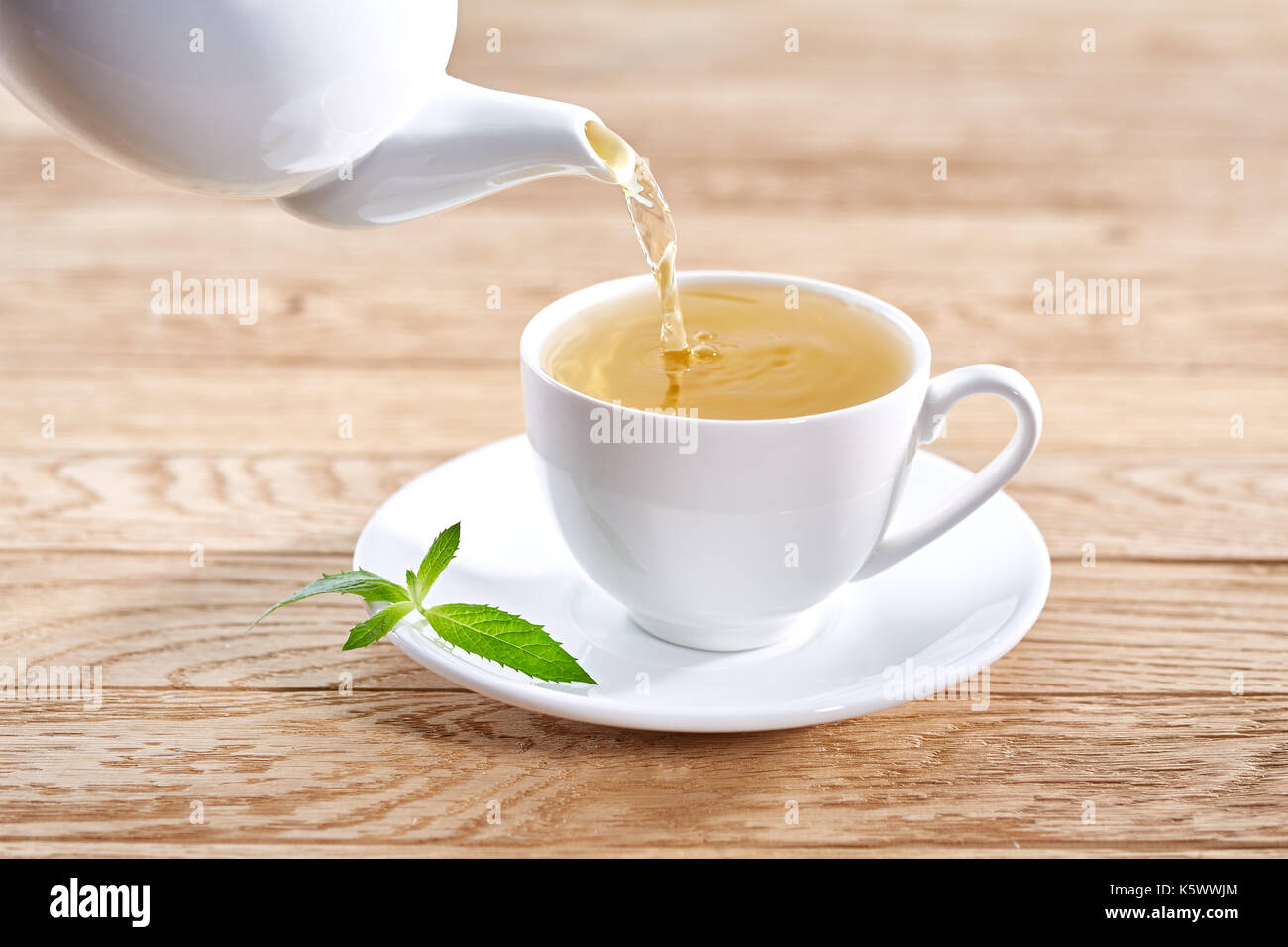 Tasse de thé vert et de théière sur fond de table en bois blanc. Banque D'Images