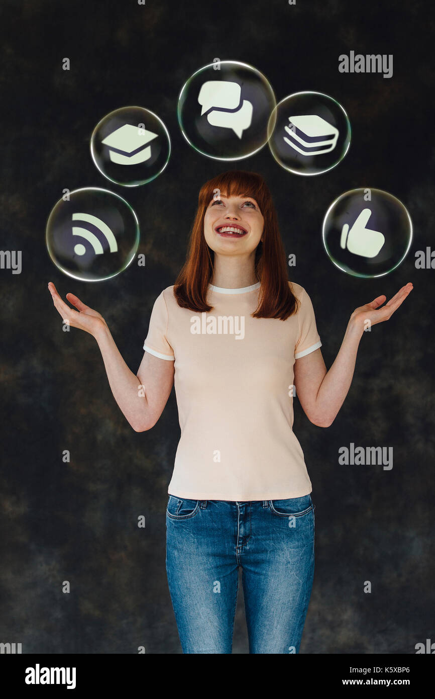 Portrait d'une jeune femme tenant son bras et jusqu'à la tout en souriant. Il y a des bulles de vecteur avec les icônes de la vie en eux arou flottante Banque D'Images