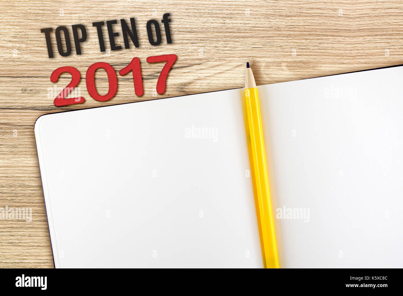 Vue du dessus top ten de l'année 2017 nouveau numéro de rouge à blanc avec l'ordinateur portable ouvert et crayon jaune sur table en bois haut,des maquettes pour l'ajout de votre contenu ou de la conception. Banque D'Images