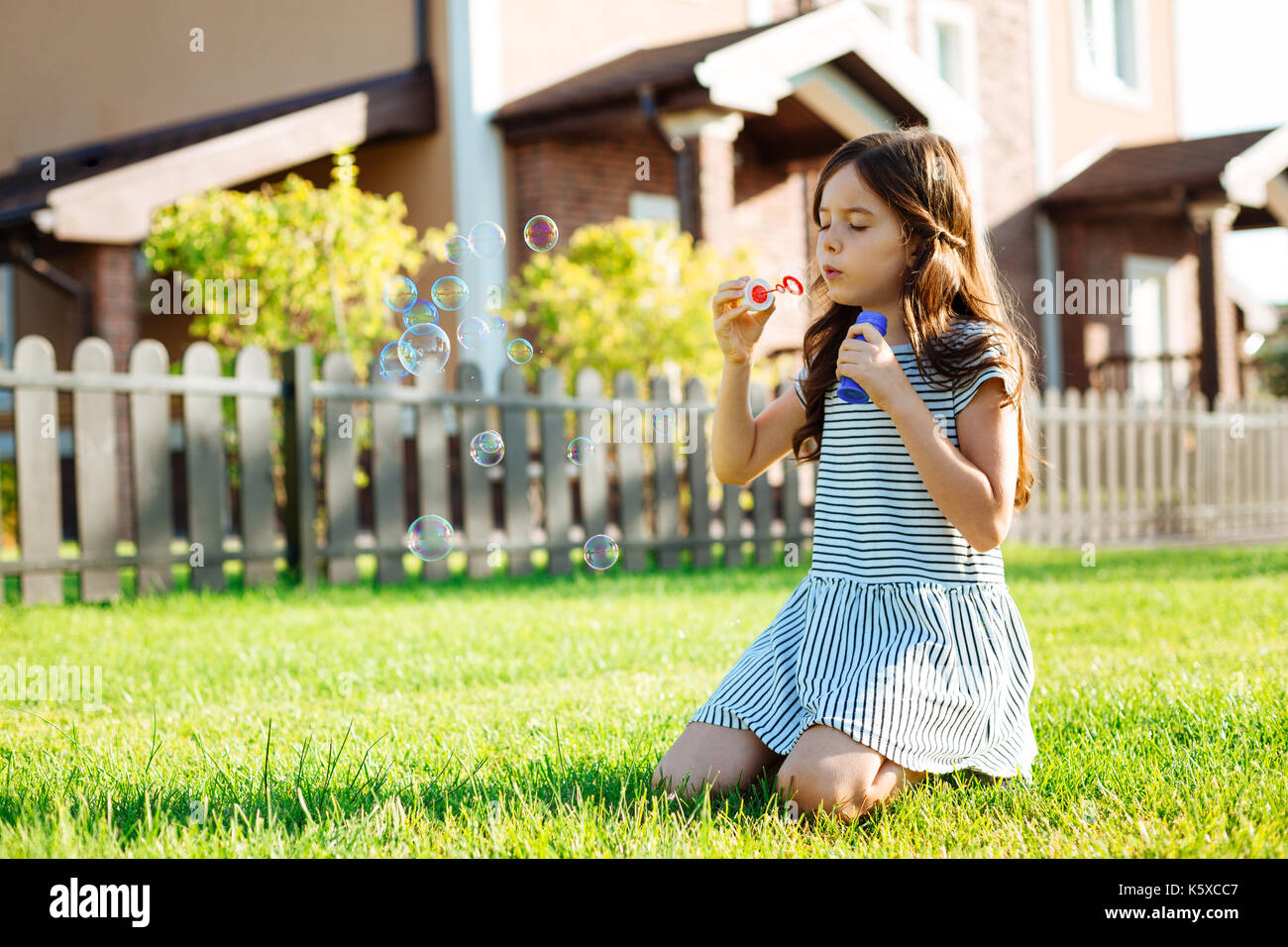 Cute little girl blowing soap bubbles Banque D'Images