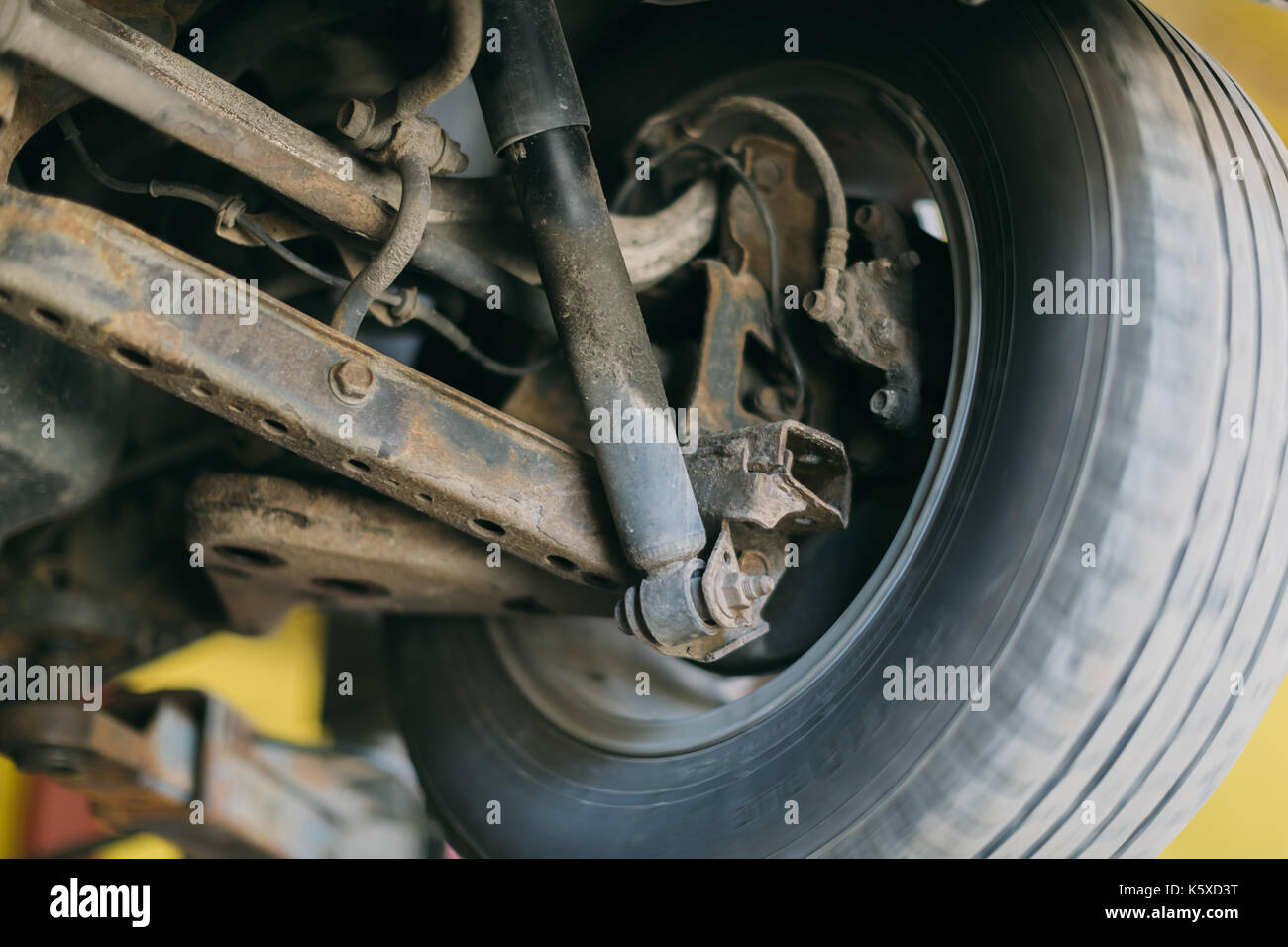 Roue de voiture Vue de dessous. garagiste a soulevé la voiture sur l'ascenseur. Banque D'Images Roue de voiture Vue de dessous. garagiste a soulevé la voiture sur l'ascenseur. Banque D'Images