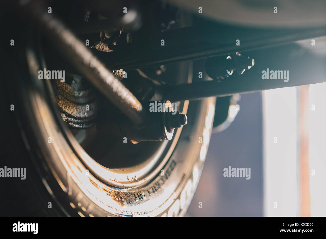 Roue de voiture Vue de dessous. garagiste a soulevé la voiture sur l'ascenseur. Banque D'Images Roue de voiture Vue de dessous. garagiste a soulevé la voiture sur l'ascenseur. Banque D'Images