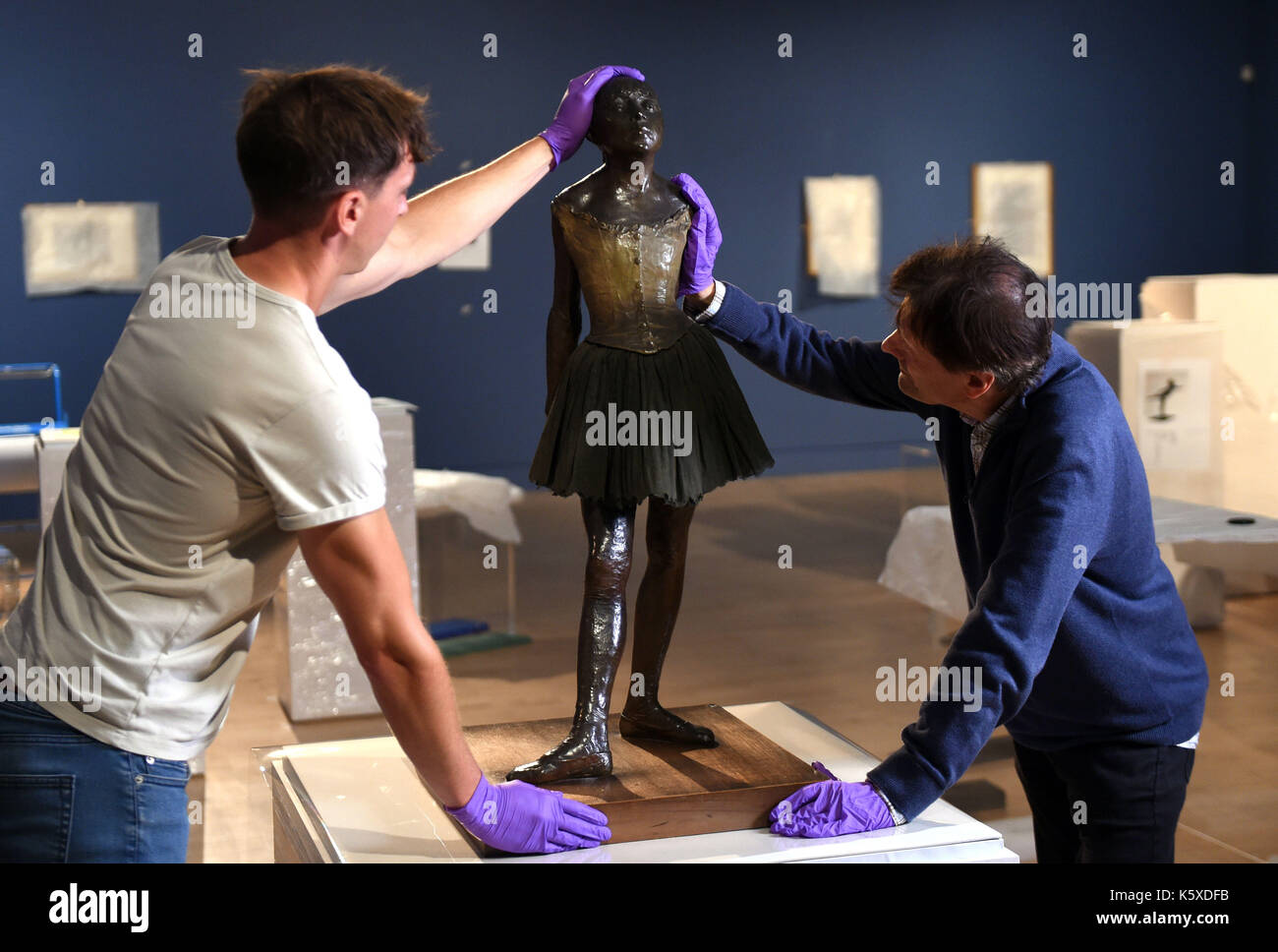 La sculpture en bronze « Little Dancer aged 14ans » d'Edgar Degas est mise en place par Tim Matthews (à gauche) et Nik Zolman (à droite) faisant partie d'une nouvelle exposition, « Degas: A passion for Perfection », au Fitzwilliam Museum de Cambridge. Banque D'Images