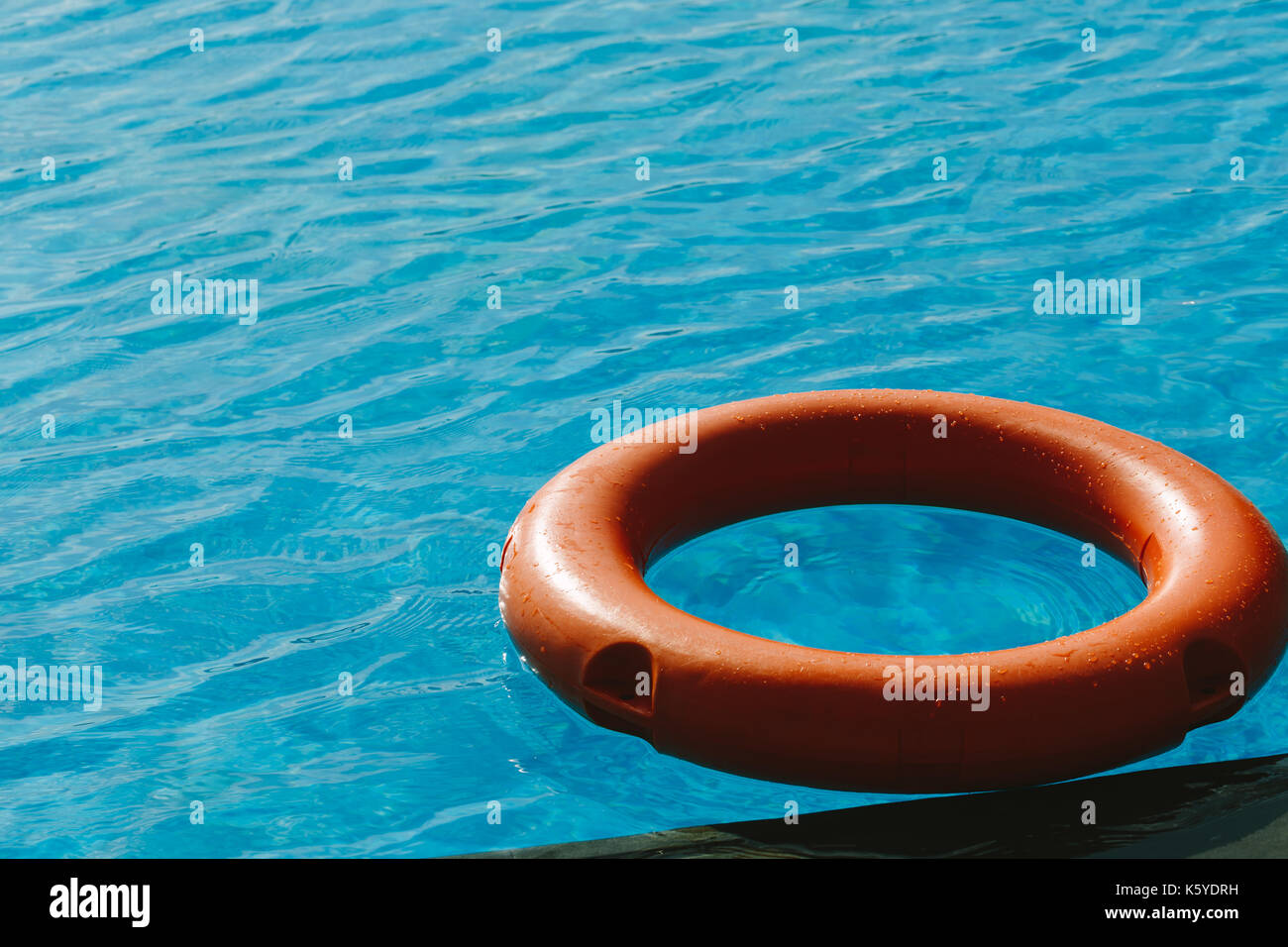 Bouée orange dans le bleu de l'eau. Banque D'Images