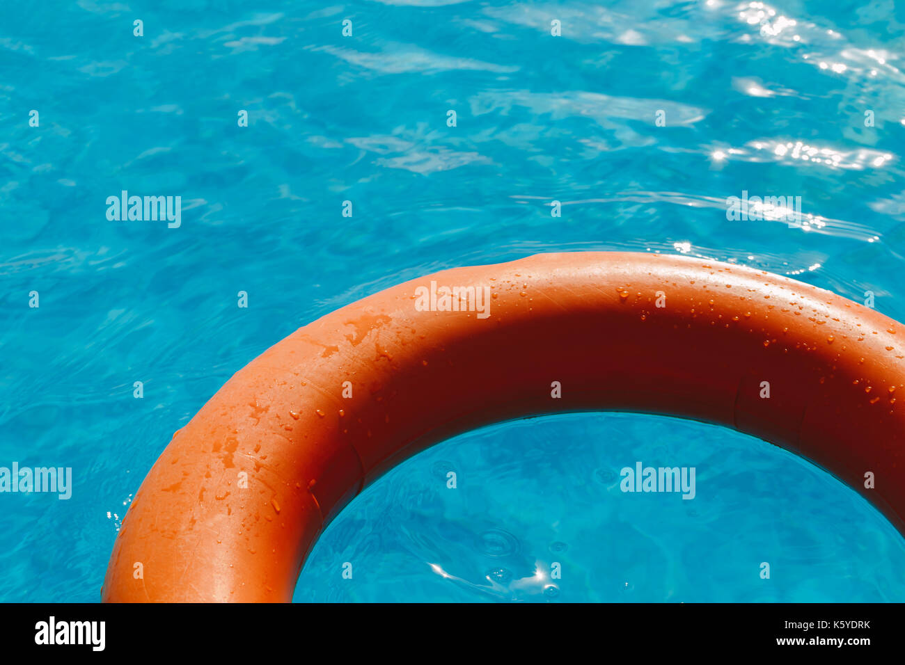 Bouée orange dans le bleu de l'eau. Banque D'Images