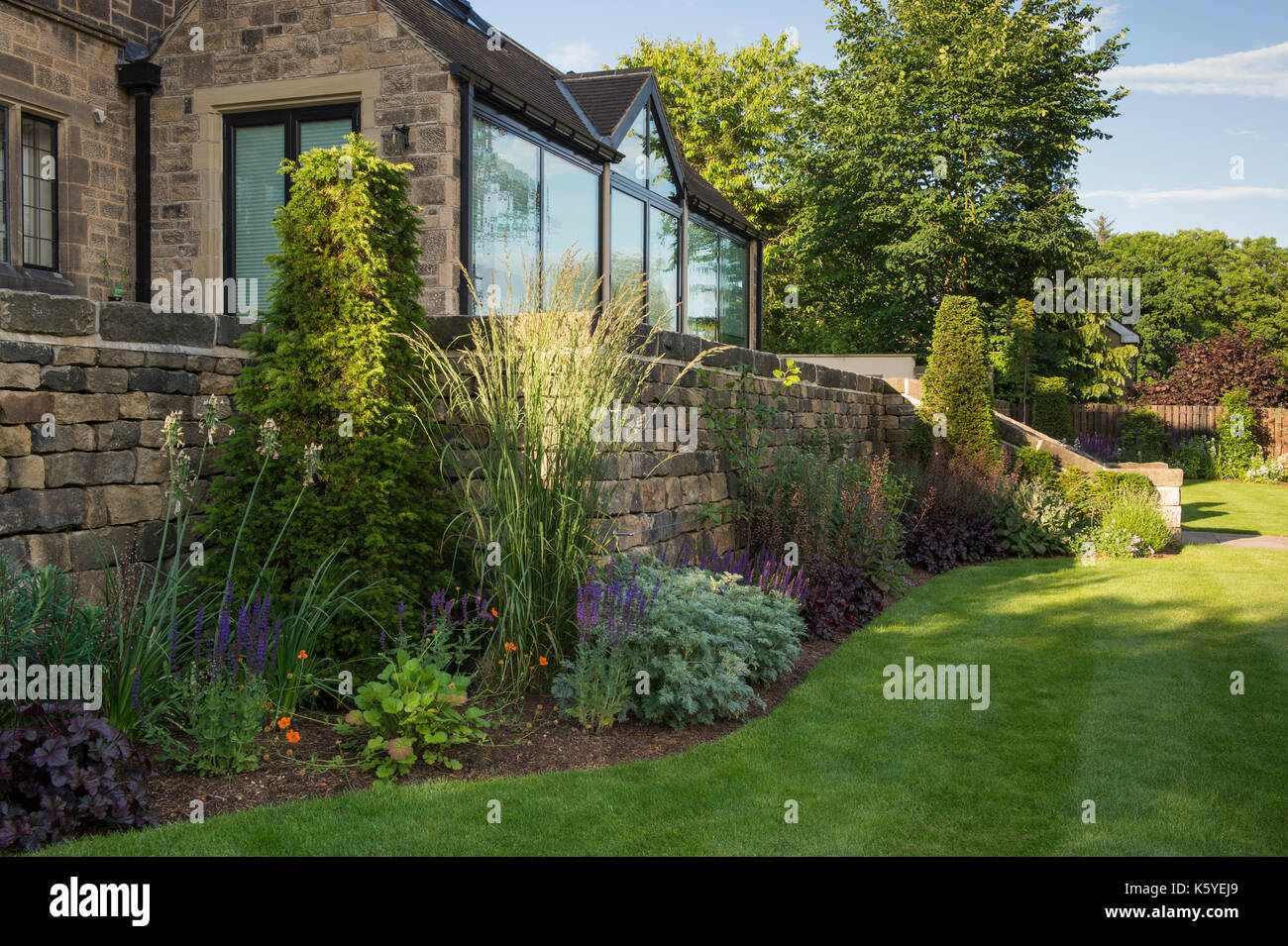 Belle, privé, traditionnelle, paysagée, country garden, West Yorkshire, Angleterre, Royaume-Uni - l'été plantes herbacées sur frontière par chambre. Banque D'Images