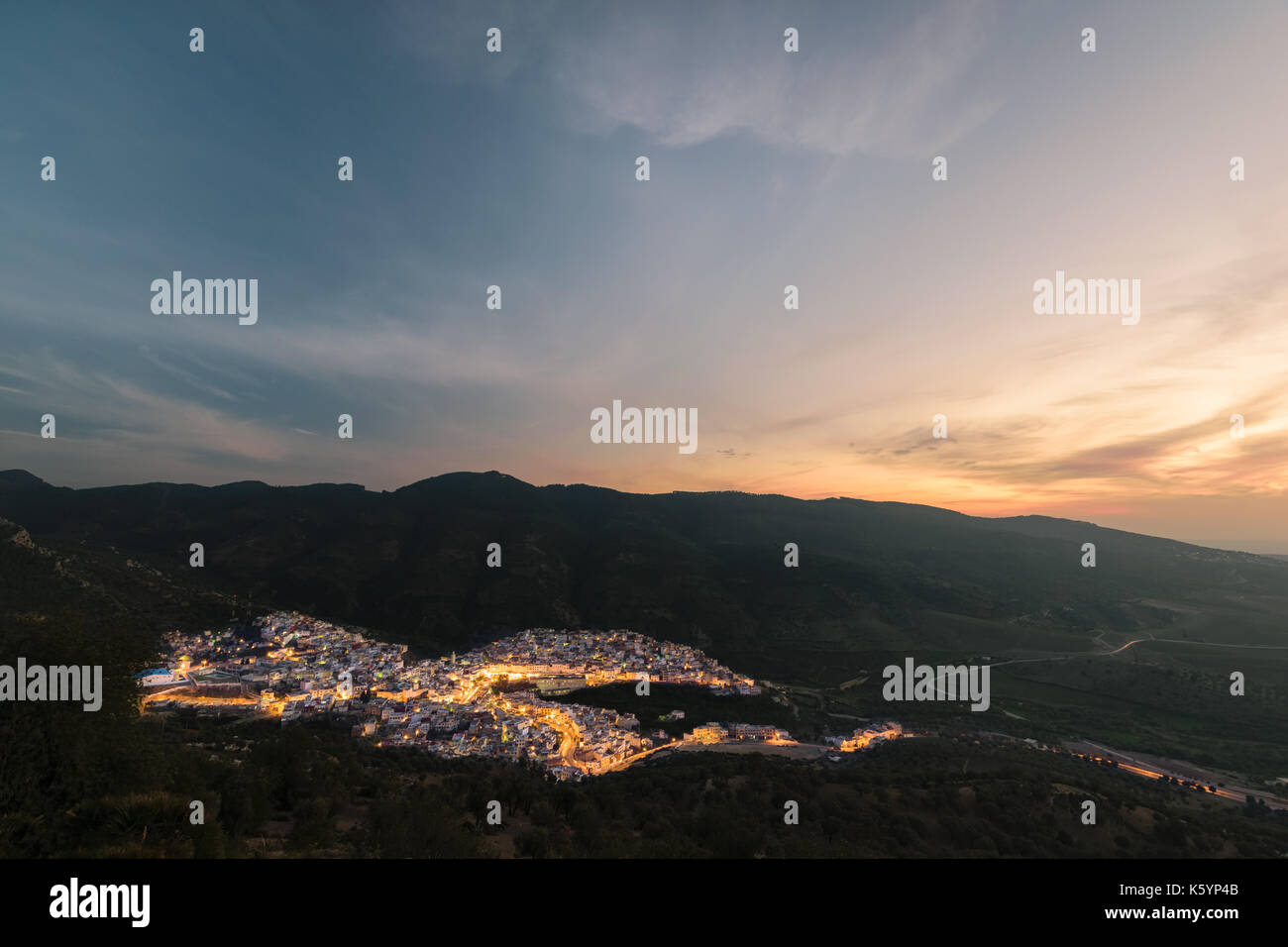 Une longue exposition de la ville de Moulay Idris religieuse au Maroc au coucher du soleil avec un ciel magnifique et quelques éclairs dans les rues. Banque D'Images