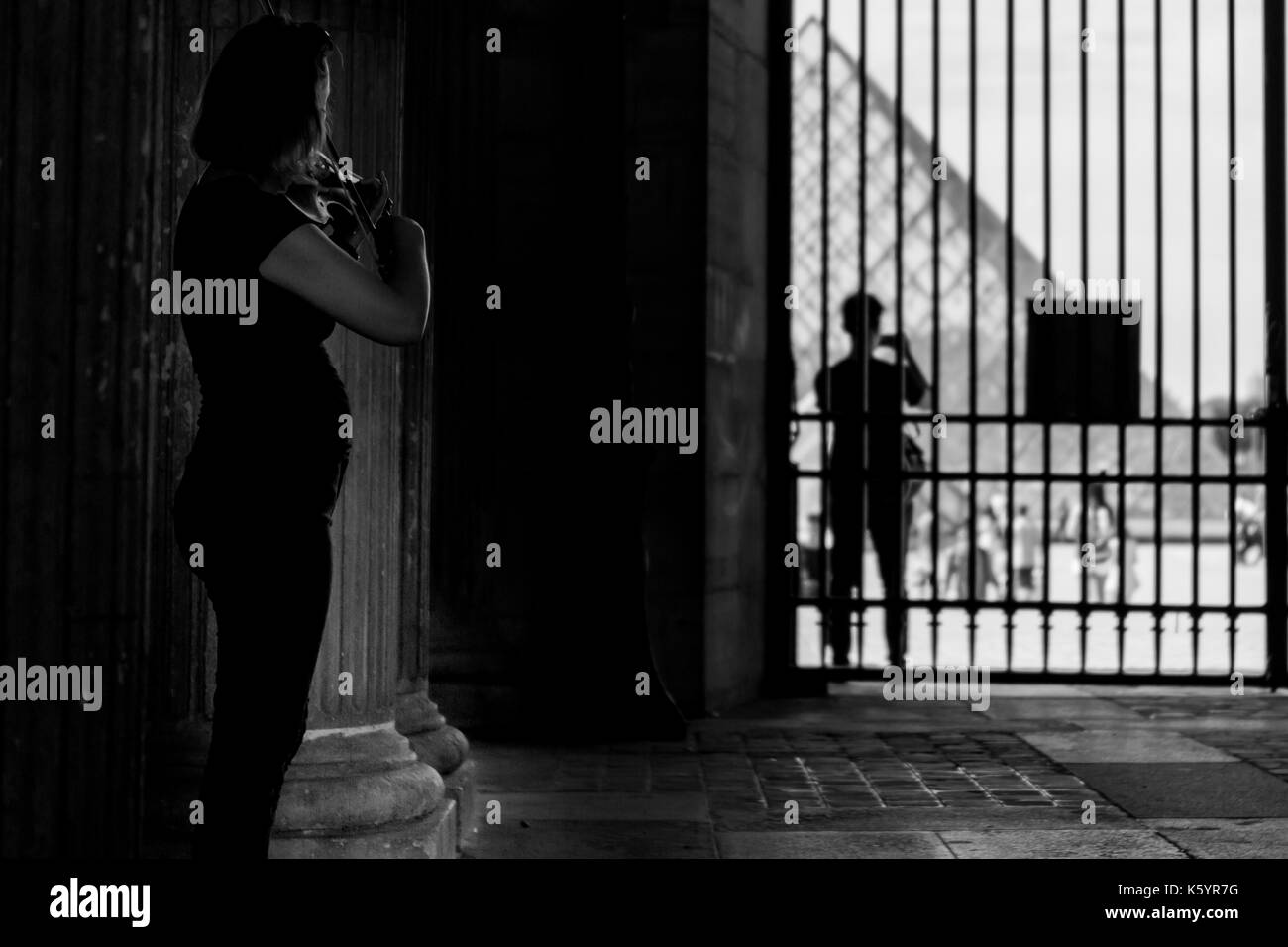 Une jeune femme à jouer du violon à l'une des entrées en du Louvre, Paris Banque D'Images