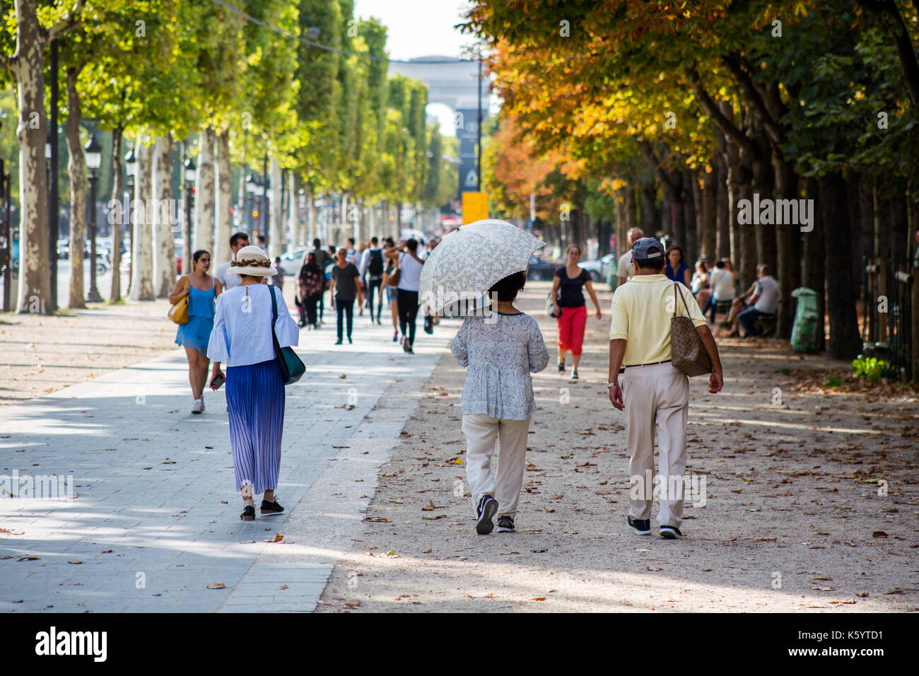 Les gens qui marchent le long d'une rue bordée d'direction arc de triomphe à Paris sur une journée d'été Banque D'Images