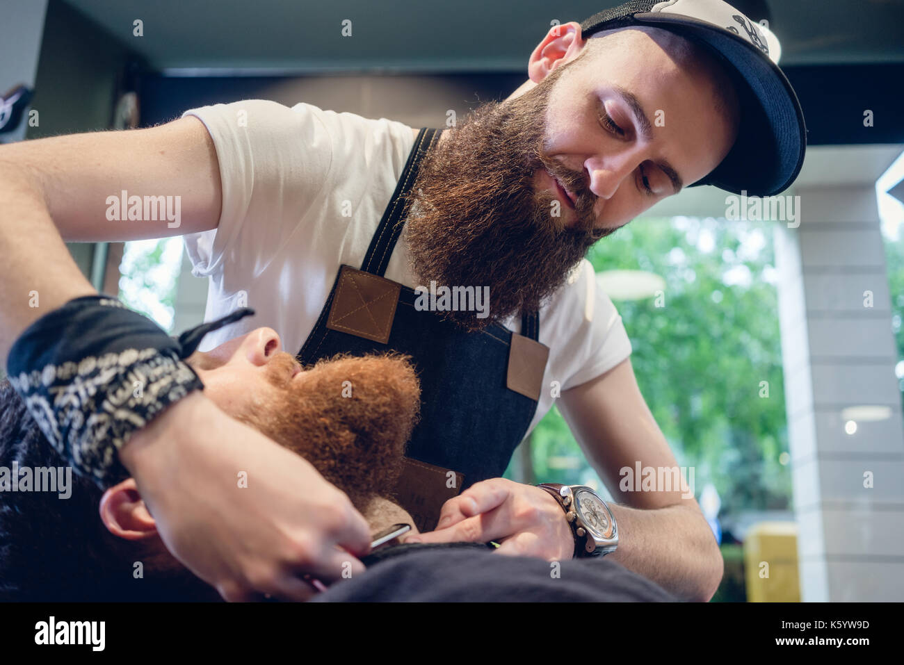 Jeune homme barbu prêt pour le rasage dans le salon de coiffure d'une compétence Banque D'Images