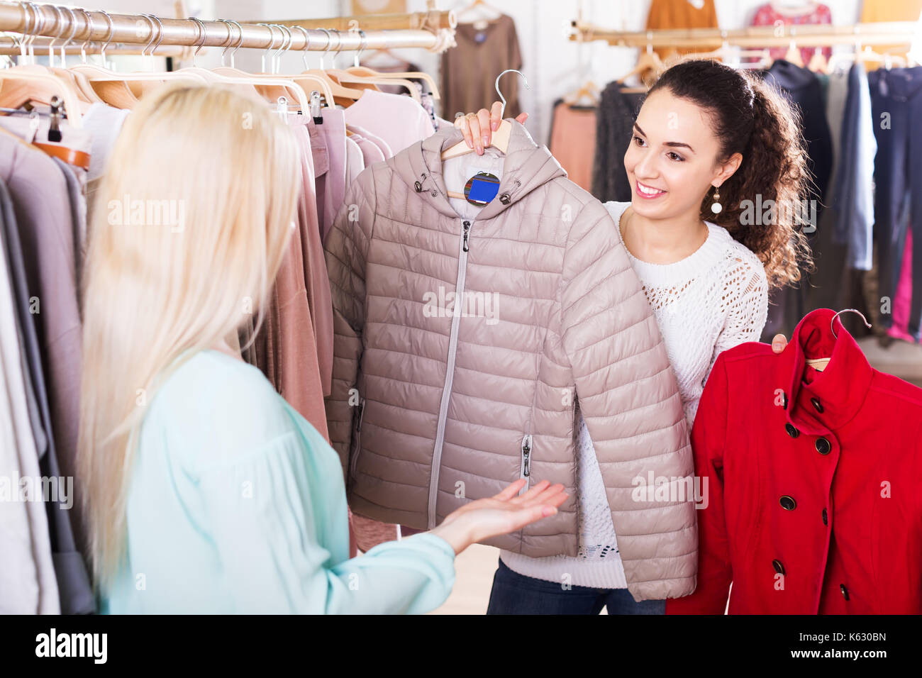 Deux jolies copines choisir veste chaude dans shop and smiling Banque D'Images