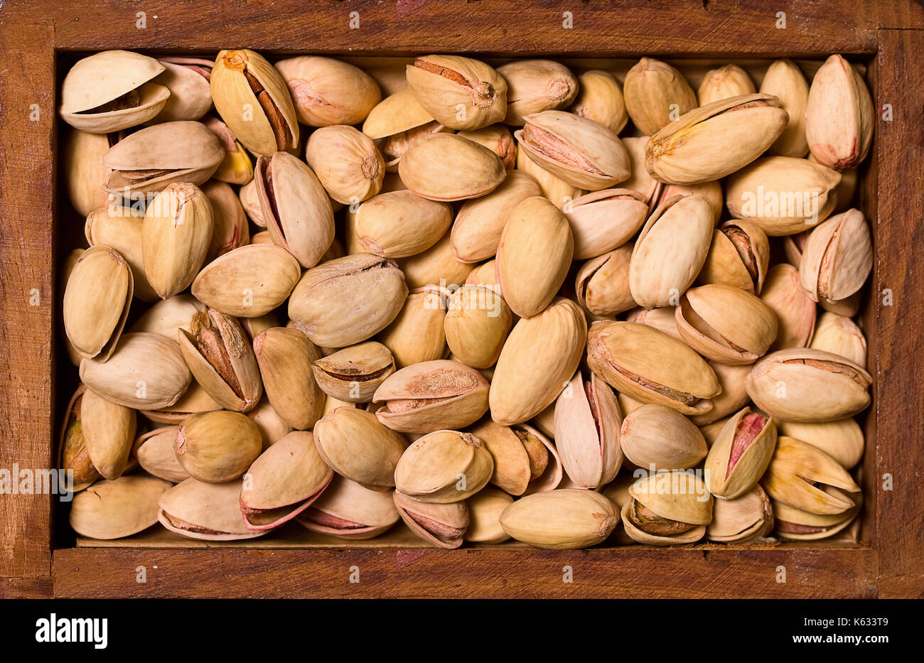 Arrière-plan de pistaches grillées salées dans un bol carré en bois Banque D'Images