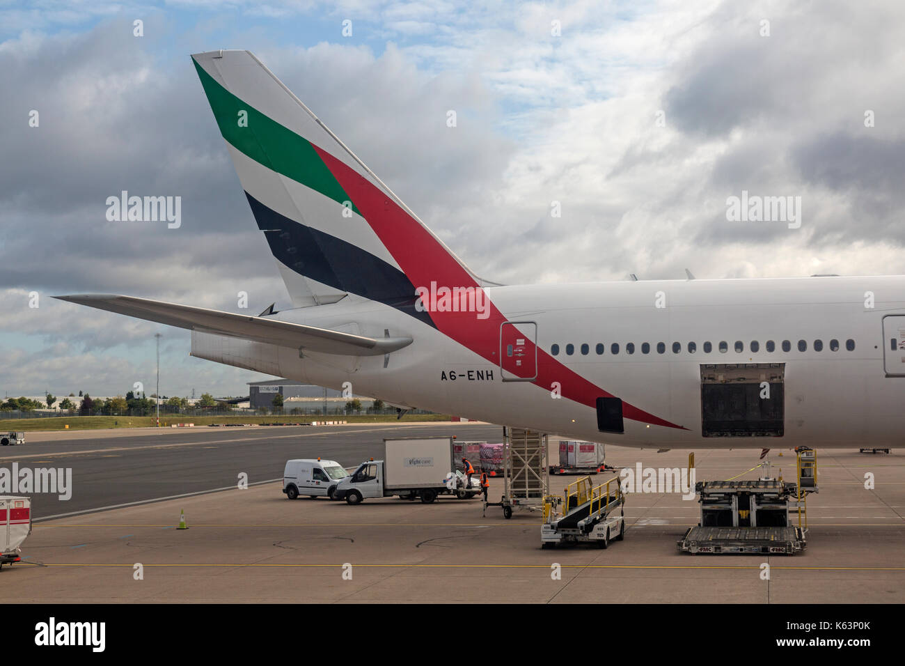 Boeing 777 de la compagnie aérienne Emirates, A6-ENH, d'être chargés à l'Aéroport International de Birmingham en Angleterre. La photo montre la queue et le fret et assurance en cours de chargement. Banque D'Images