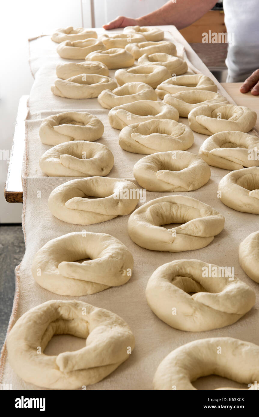 Formé pour les bagels pâte couché sur la table de cuisson dans une boulangerie Banque D'Images