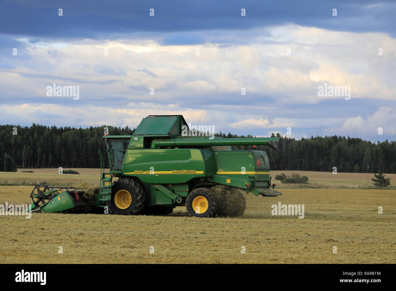 Salo, Finlande - le 25 août 2017 : moisson avec moissonneuse-batteuse John Deere 9460i à dusktime sur soirée d'automne en milieu rural au sud de la Finlande. Banque D'Images