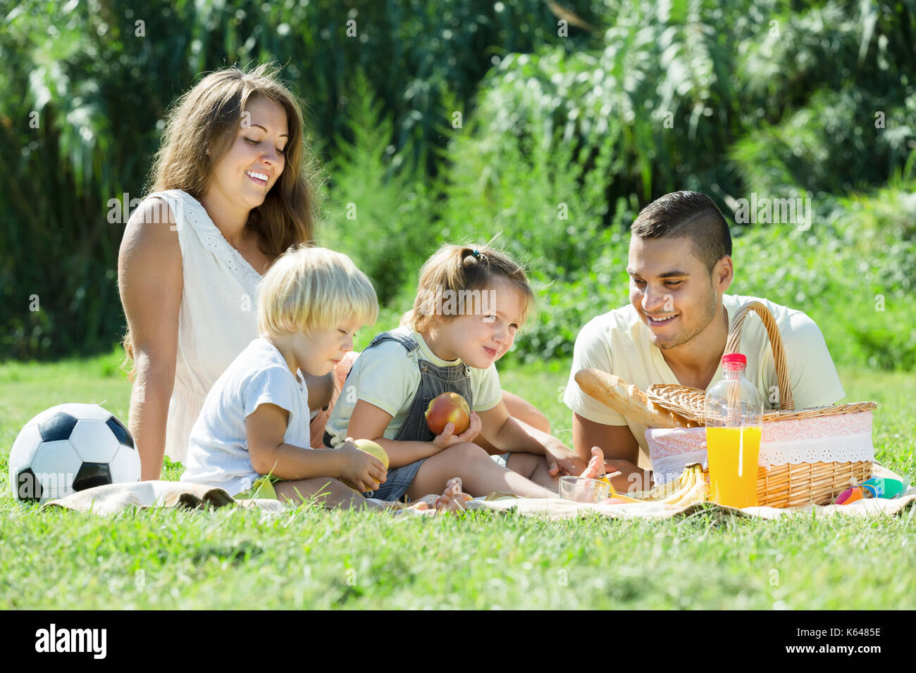 Jeune famille de quatre having picnic à campagne Banque D'Images