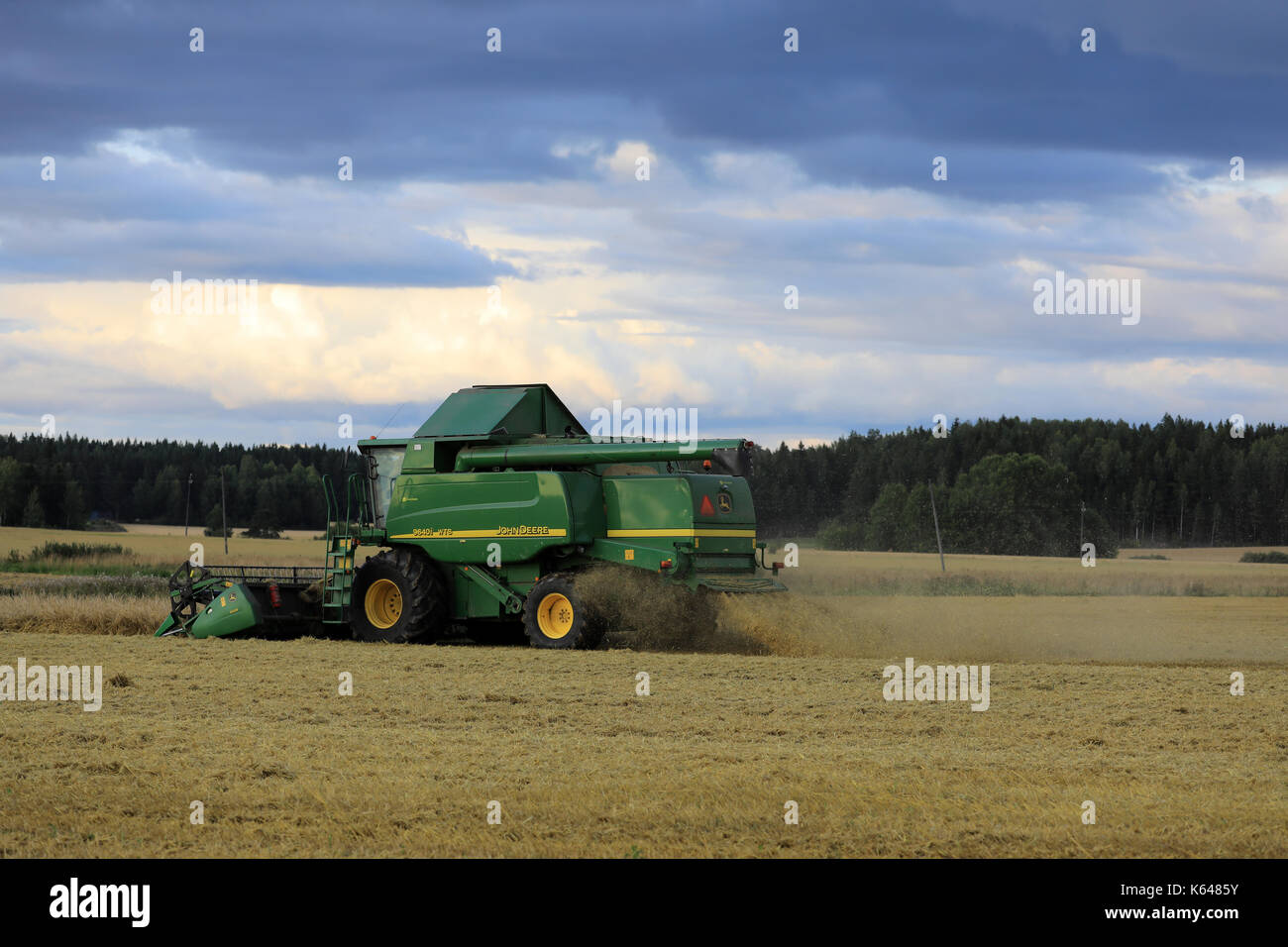 Salo, Finlande - le 25 août 2017 : moisson avec moissonneuse-batteuse John Deere 9460i sur soirée d'automne en milieu rural au sud de la Finlande. Banque D'Images