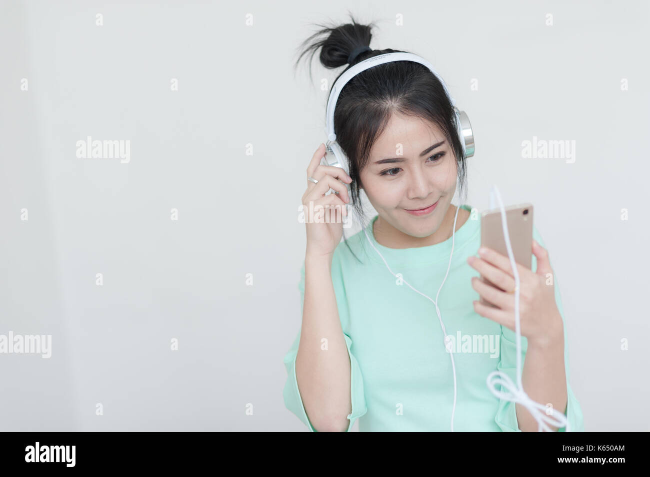 Young attractive asian woman listening music sur lors de l'utilisation de casque pour smartphone réseau social. internet des objets pour concept de vie moderne Banque D'Images