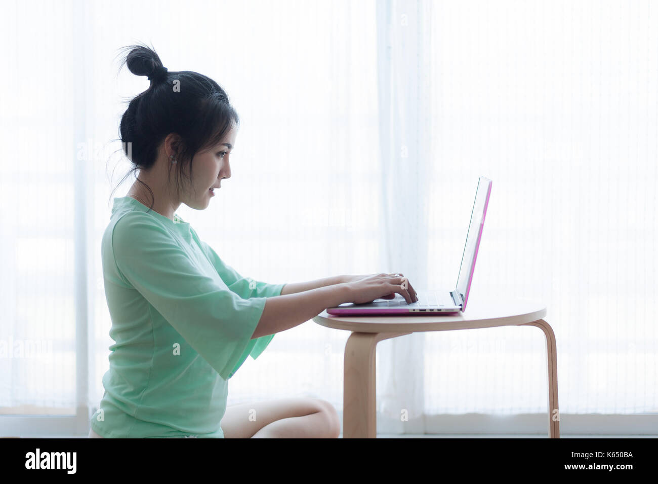 Young attractive asian woman free typing on laptop clavier de l'ordinateur tout en étant assis sur le plancher. travailler à la maison et de l'apprentissage en ligne concept Banque D'Images