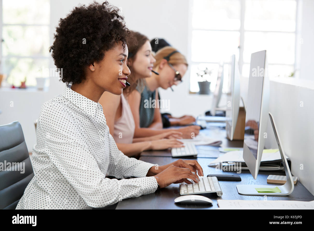 Jeune femme noire travaillant au bureau de l'ordinateur avec casque ...