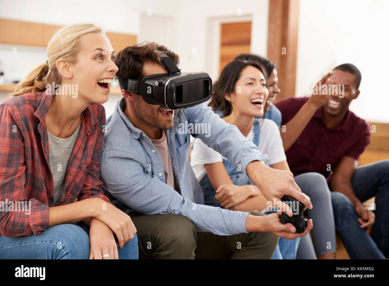 Les amis à jouer à jeu avec casque de réalité virtuelle Banque D'Images