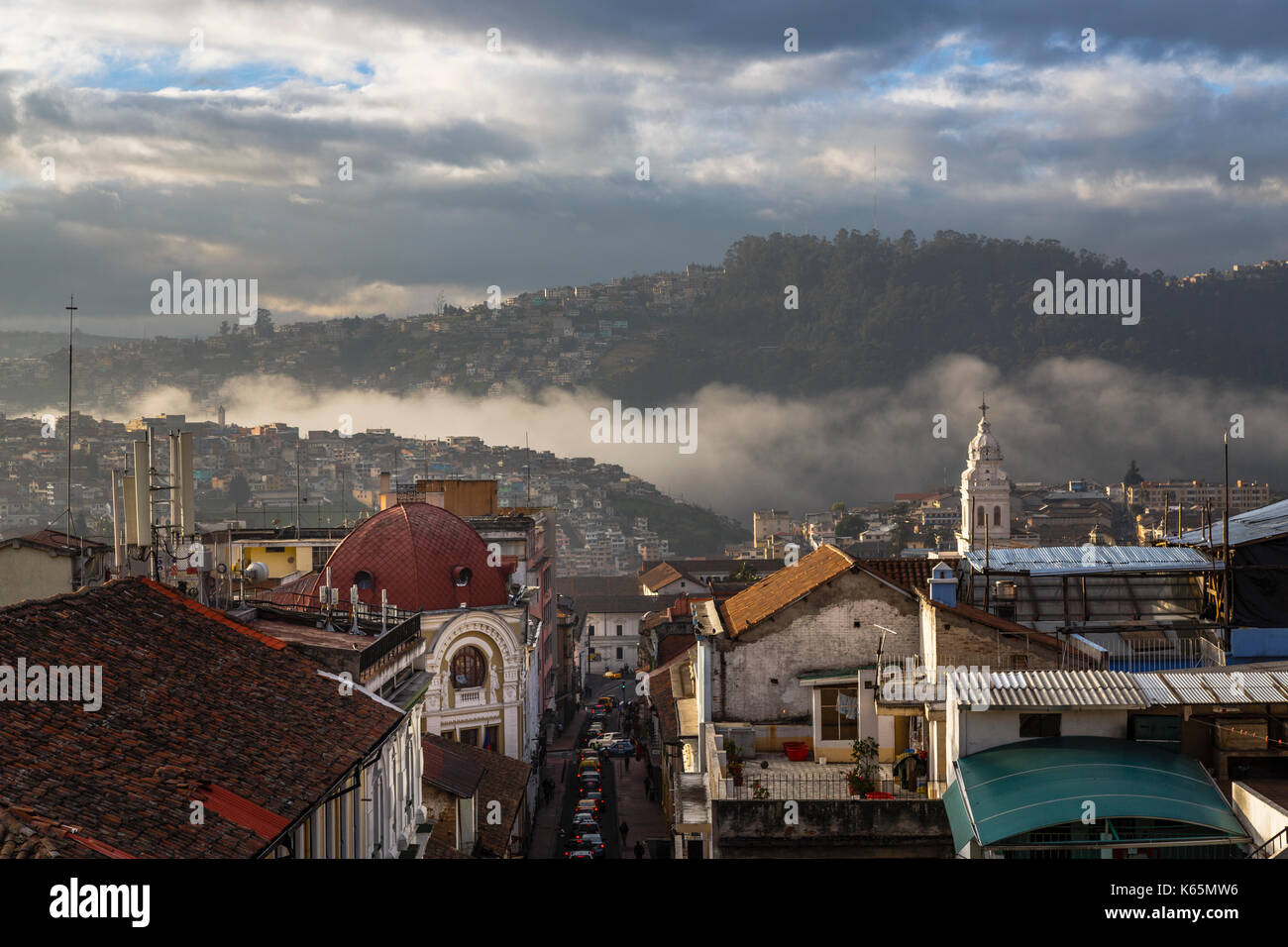 Ciel dramatique et brume matinale rouler dans une vallée dans le centre historique, centre-ville de Quito, capitale de l'Équateur, en Amérique du Sud Banque D'Images