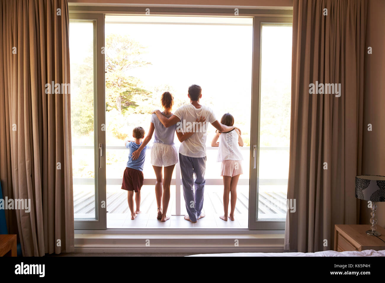 Vue arrière de la famille Sur balcon donnant sur New Day Banque D'Images