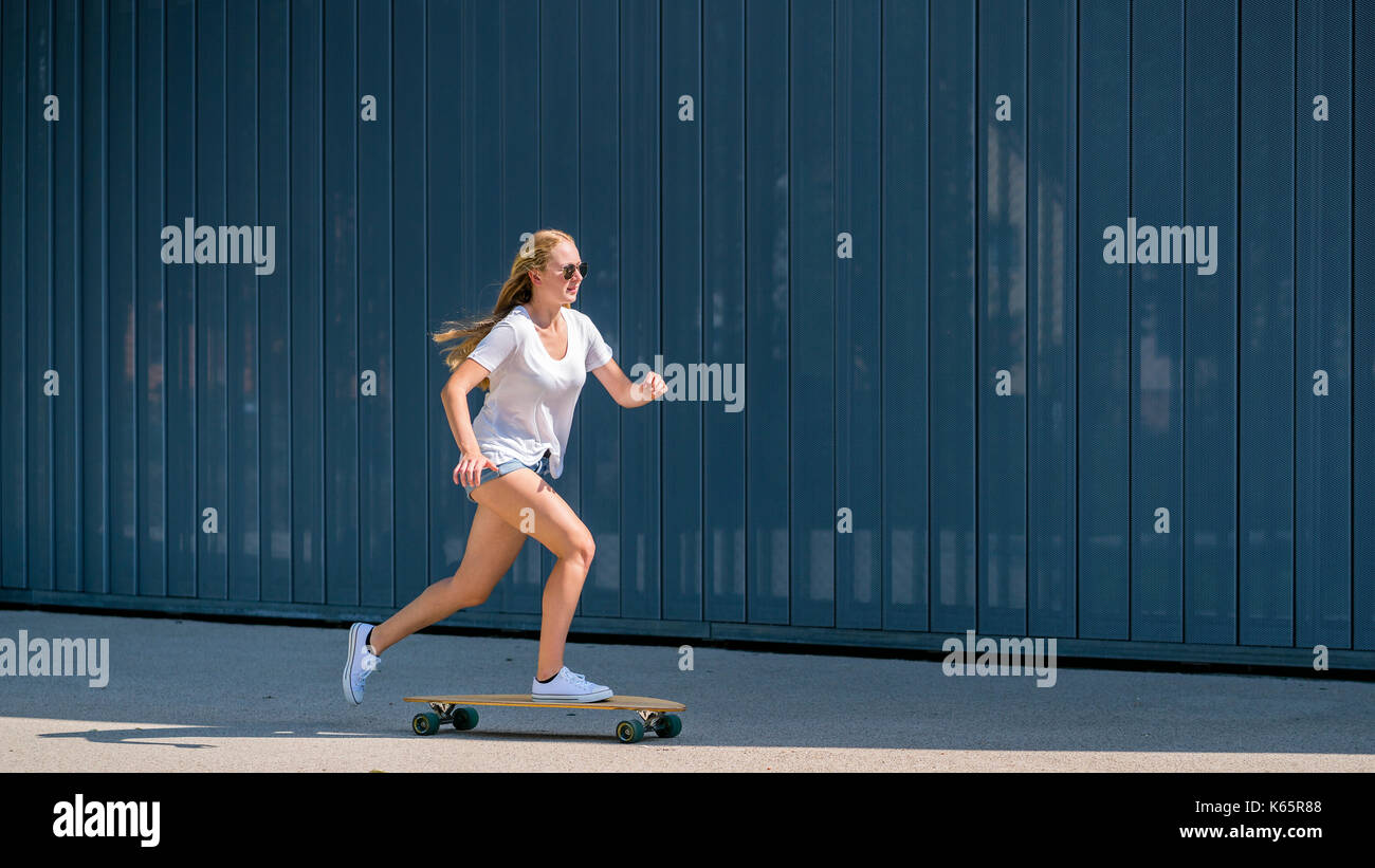 Femme, 22 ans, se déplace sur longboard Banque D'Images