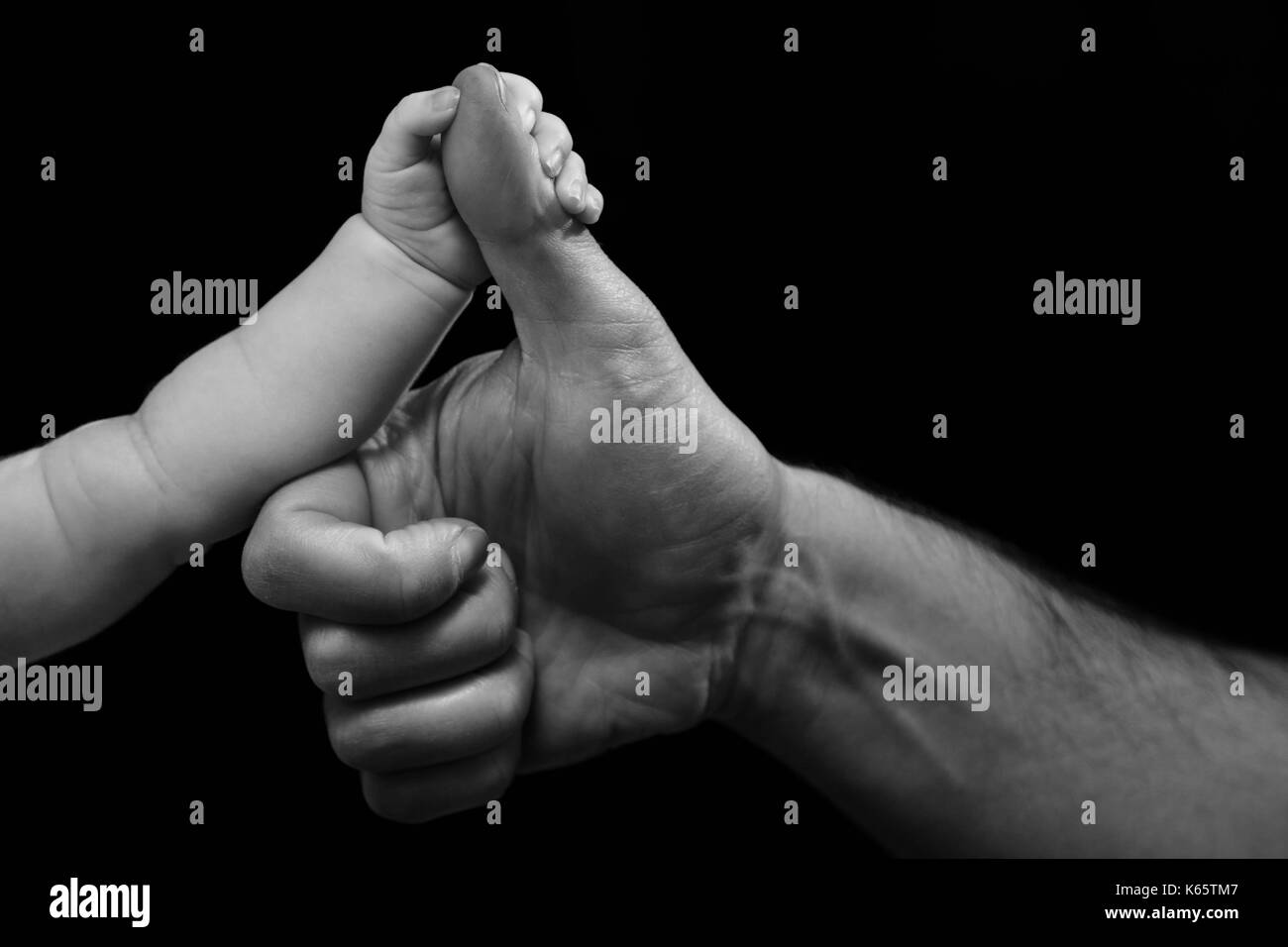 Petits Et Grands La Main Du Pere Tient Bebe Pouce Photo Stock Alamy
