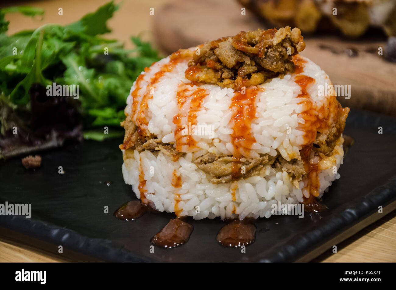 La cuisine coréenne - un riz au poulet épicé burger servi avec une salade. Banque D'Images