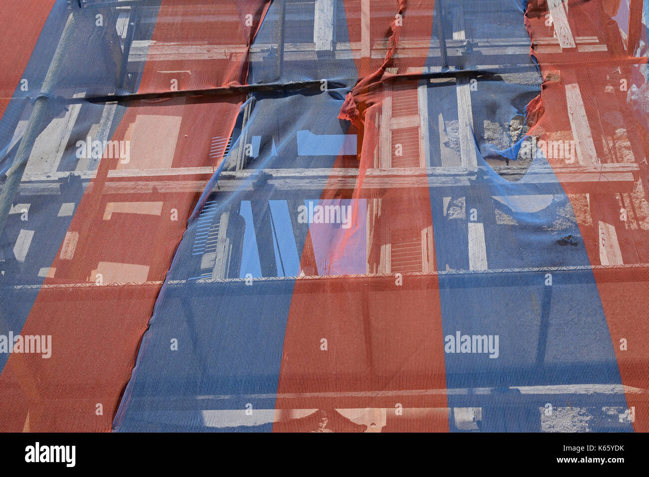 Bâtiment abandonné prêt à tomber vers le bas avec l'appui d'échafaudage et couvert par les débris colorés transparents la compensation. Banque D'Images