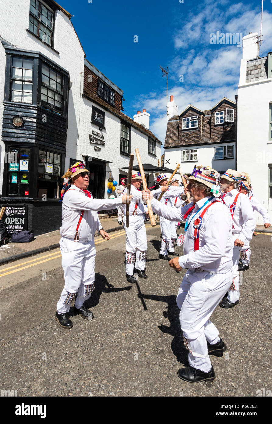 Hartley Morris Dancers, en pantalon blanc et une chemise rouge, les attelles, les chapeaux de paille, la danse et la tenue de poteaux par The Old Curiosity Shop, Broadstairs. Banque D'Images