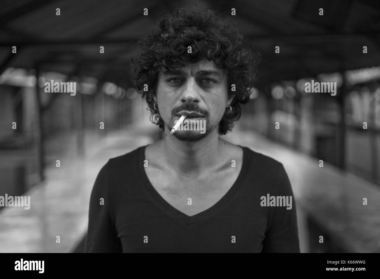 Serious mixed race man fumer des cigarettes Banque D'Images