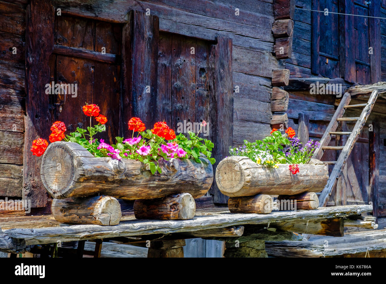 Décoration de fleurs typiques de l'ancien sur les maisons en bois de la ville de montagne Banque D'Images