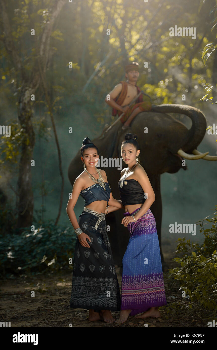 Deux femmes en vêtements traditionnels thaïlandais avec un cornac équitation un éléphant, Thaïlande Banque D'Images