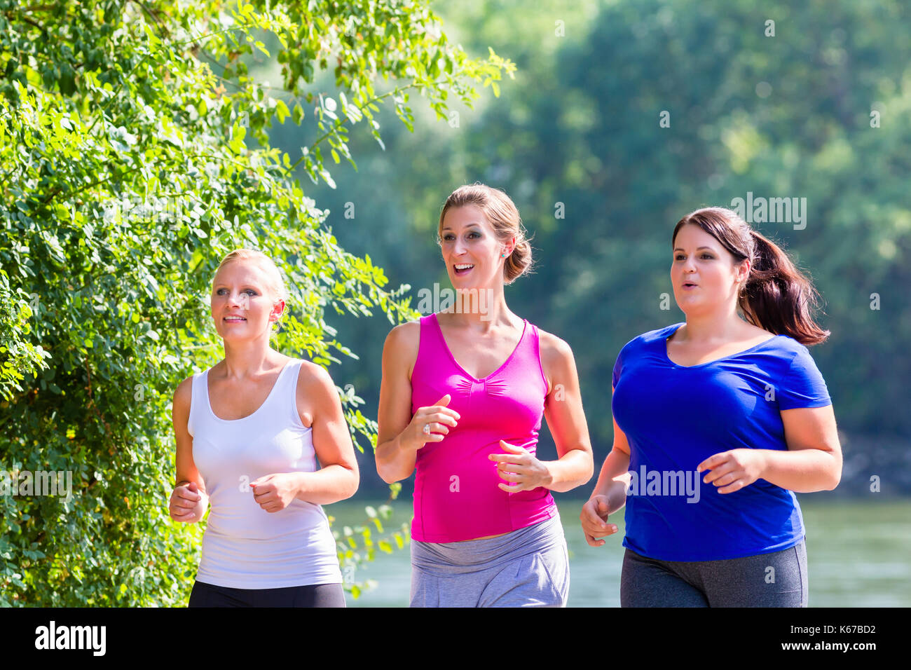 Groupe de femmes tournant au jogging au bord du lac Banque D'Images