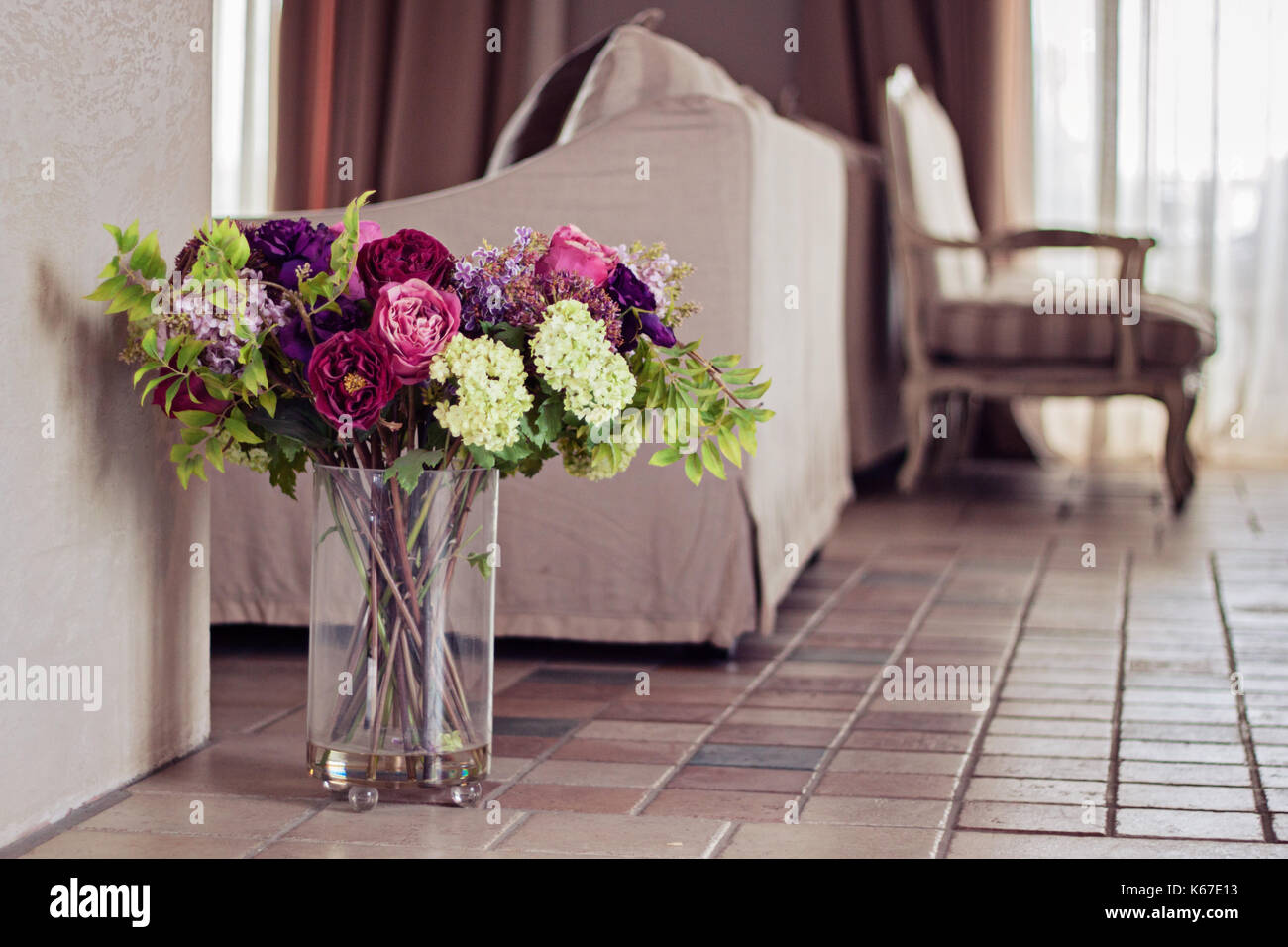 Vase rempli de fleurs artificielles dans un salon Banque D'Images